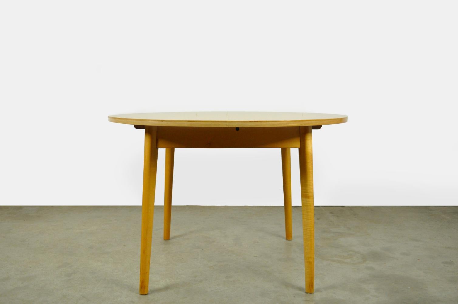 The table has a plywood top with a birch top layer. The top rests on a birch frame standing on 4 solid wooden legs. The extension of the table hangs under the table and can be folded out on hinges. No brand or designer is known to us, but it has the