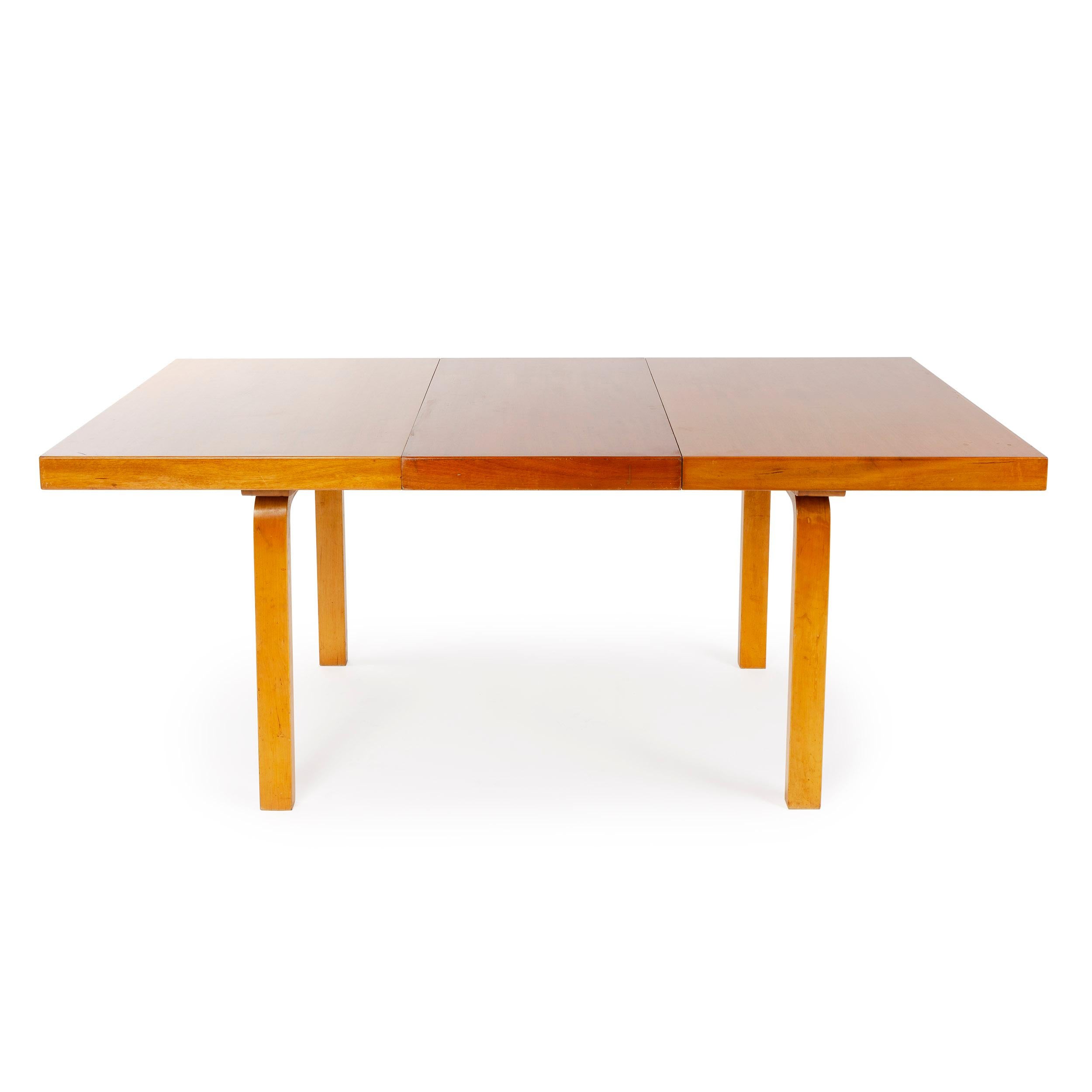 A rectangular extension dining table with a laminated birch top and solid bentwood legs, having two (2) self storing 19.5
