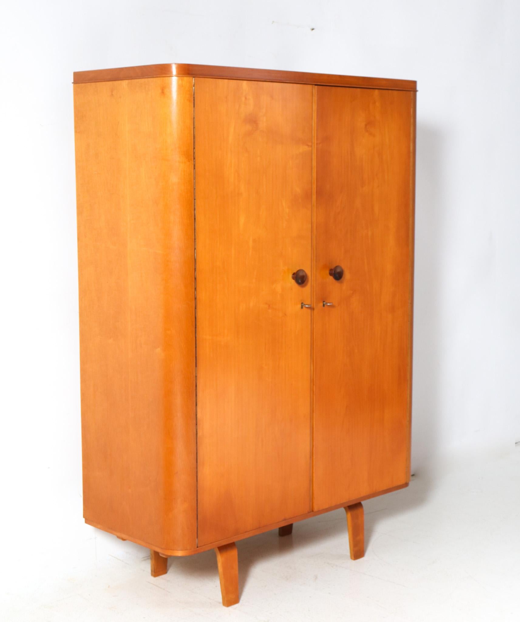 Magnificent and ultra rare Mid-Century Modern armoire or wardrobe.
Design by Cor Alons for Den Boer Gouda.
Striking Dutch design from 1949.
Original birch plywood base with the curved legs typical for the Mid-Century Modern designs by Cor Alons in