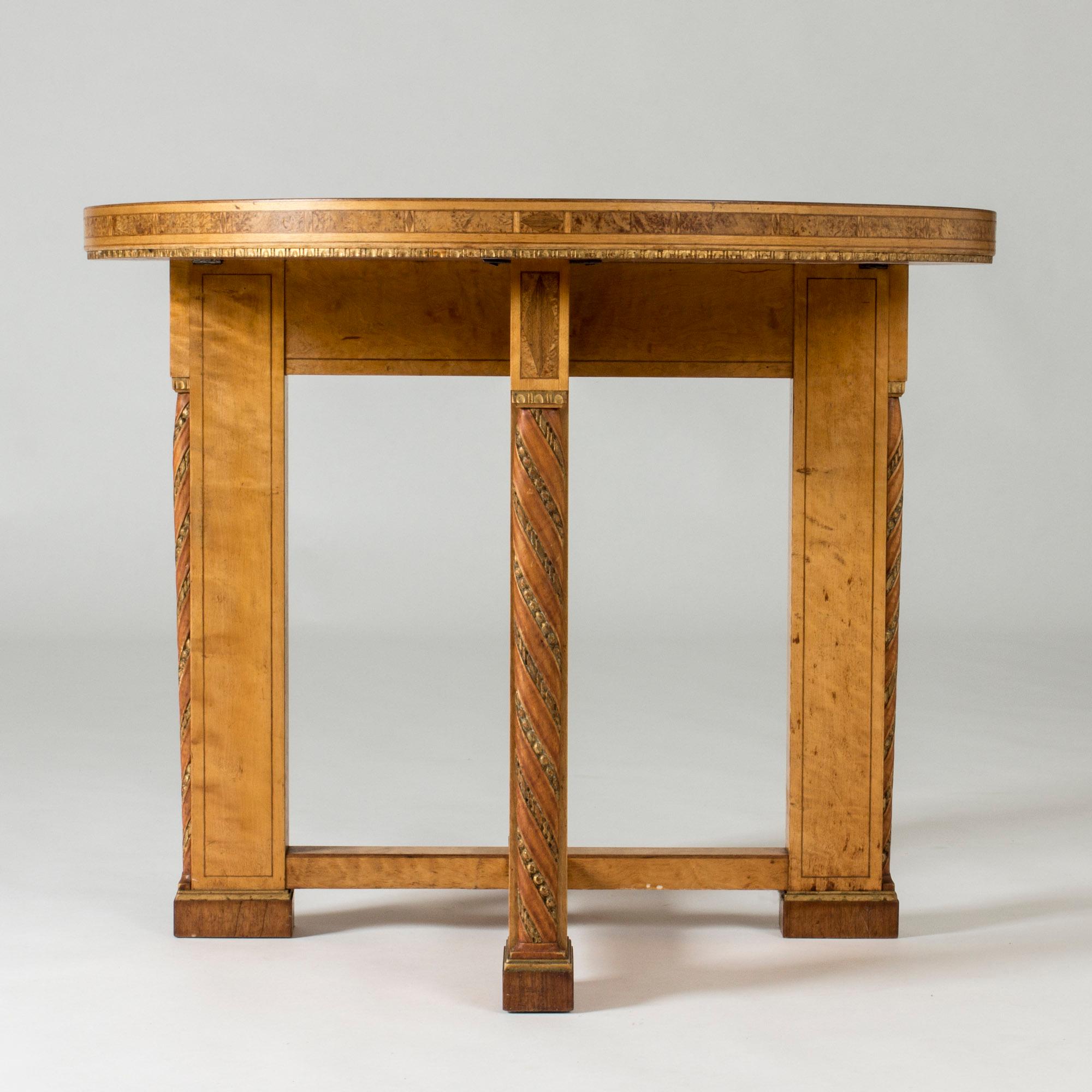 Round occasional table or small dining table by Otto and David Wretling. Compact design with elaborate graphic inlays on the sides and back, root details, and decor along the fronts that imitates leather. Made from birch and birch root. The table