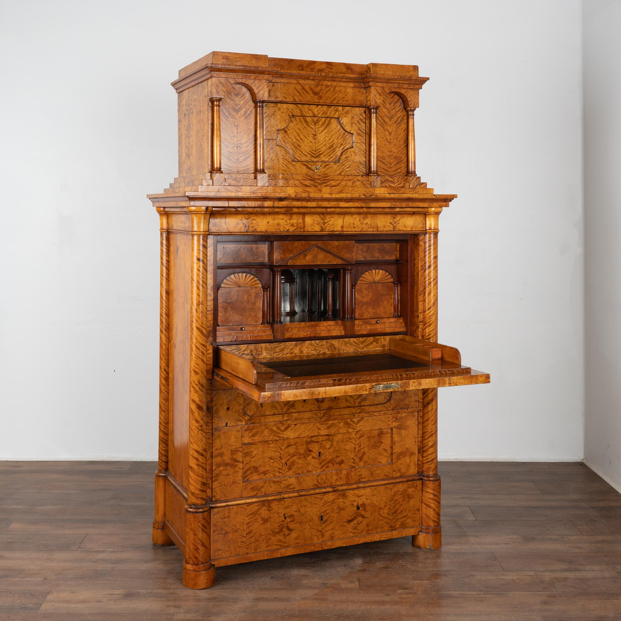 Rich birch and stately lines define this handsome Biedermeier drop front secretary.
Refer to close up photos to appreciate the stunning grain pattern of the flame birch veneer.
Multiple interior drawers and hidden storage areas are accented by the