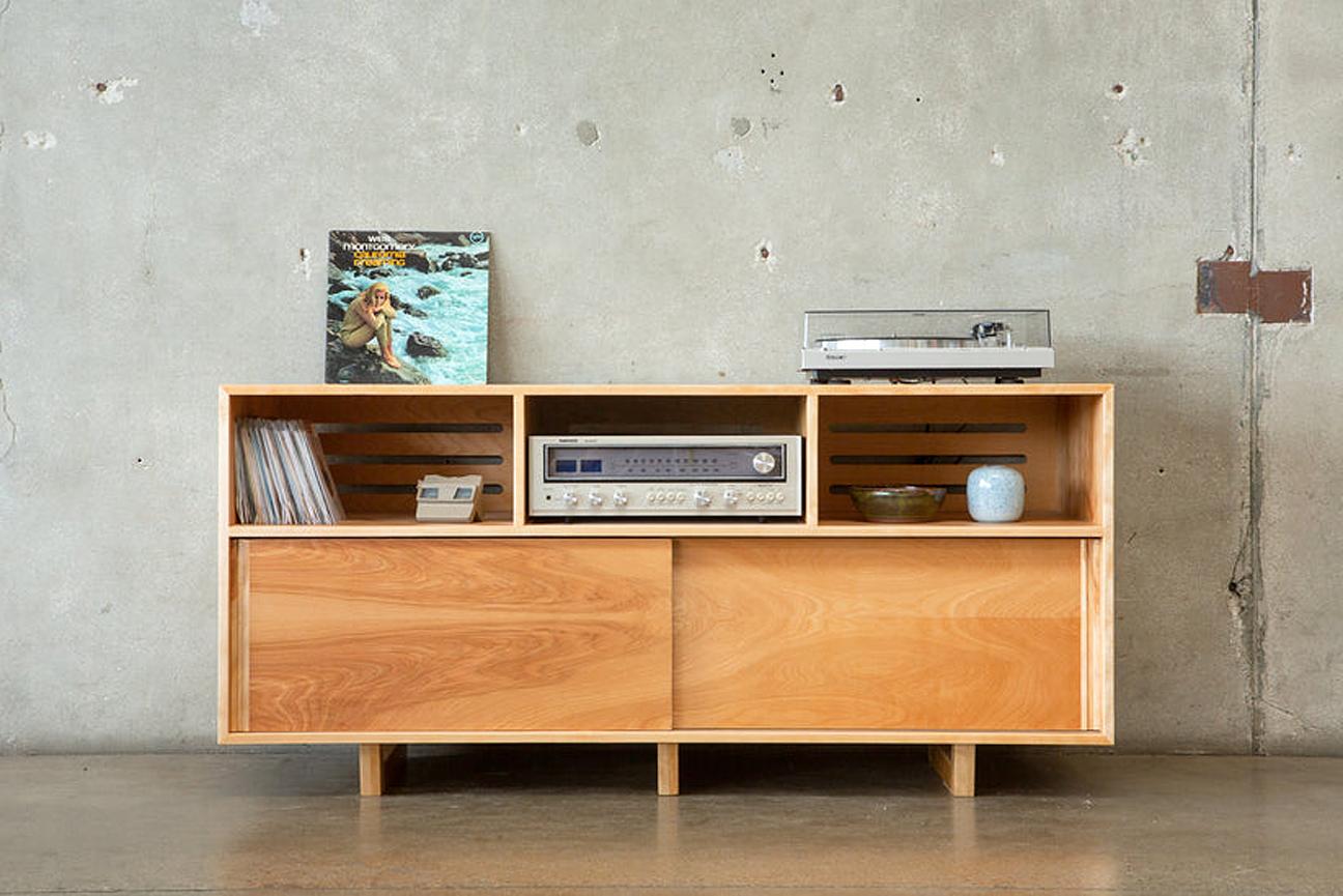 This birch stereo credenza is an original design with classic mid century modern lines. It features beautiful American natural birch with sliding doors below (protect those records from cats!) and open sections above. It has slatted openings in the