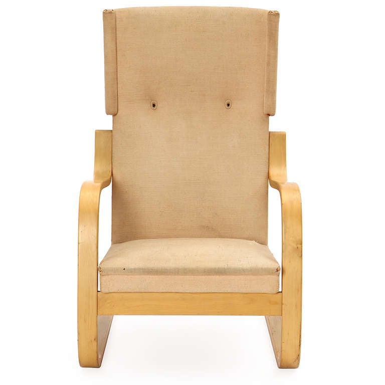 A rare and sculptural wingback lounge chair having a cantilevered laminated birch frame and retaining its original handstitched textured linen upholstery.