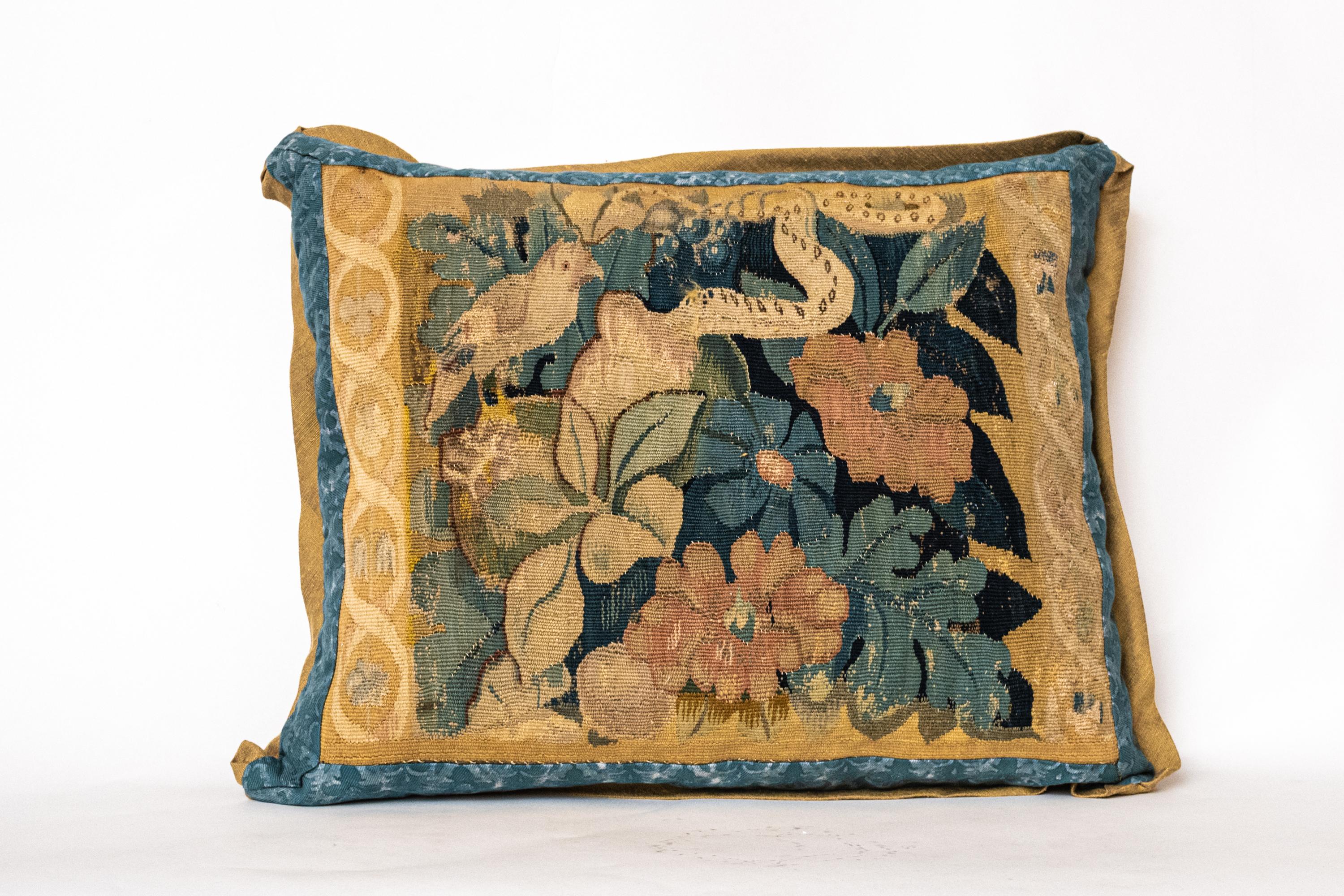 Coussin ancien en textile Fortuny représentant la tapisserie de Bruxelles du XVIIe siècle avec des motifs classiques de faune et de flore. Bords et dos biaisés en soie avec insert 50 duvet/50 plumes. Toutes les ventes sont finales

