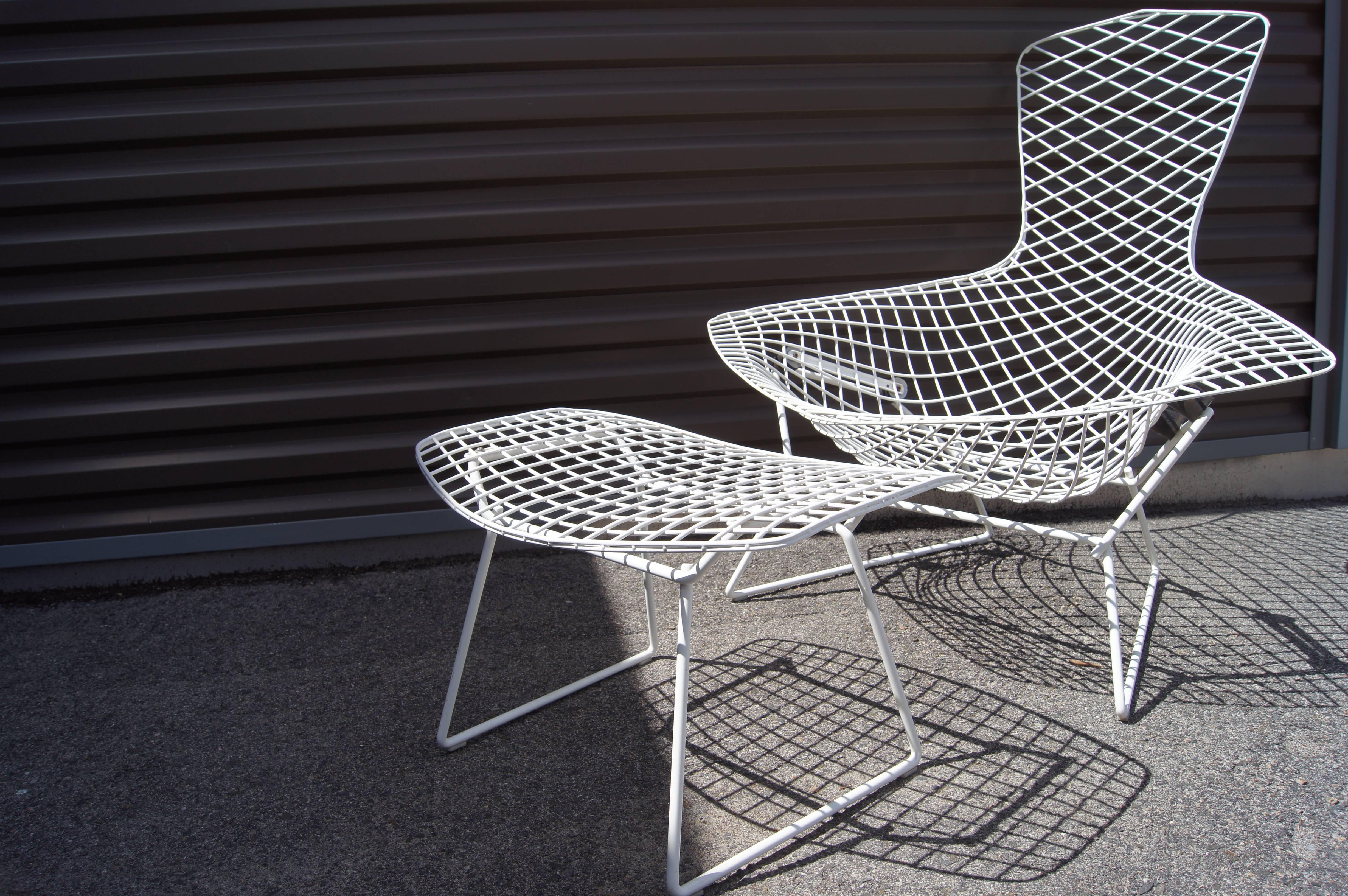 Part of Harry Bertoia's 1952 collection of sculptural wire furniture for Knoll, the fanciful Bird Chair features a low seat, a high back, and wide armrests. A durable white finish coats the steel frame. The matching ottoman is 23 in. W x 17.25 in. D