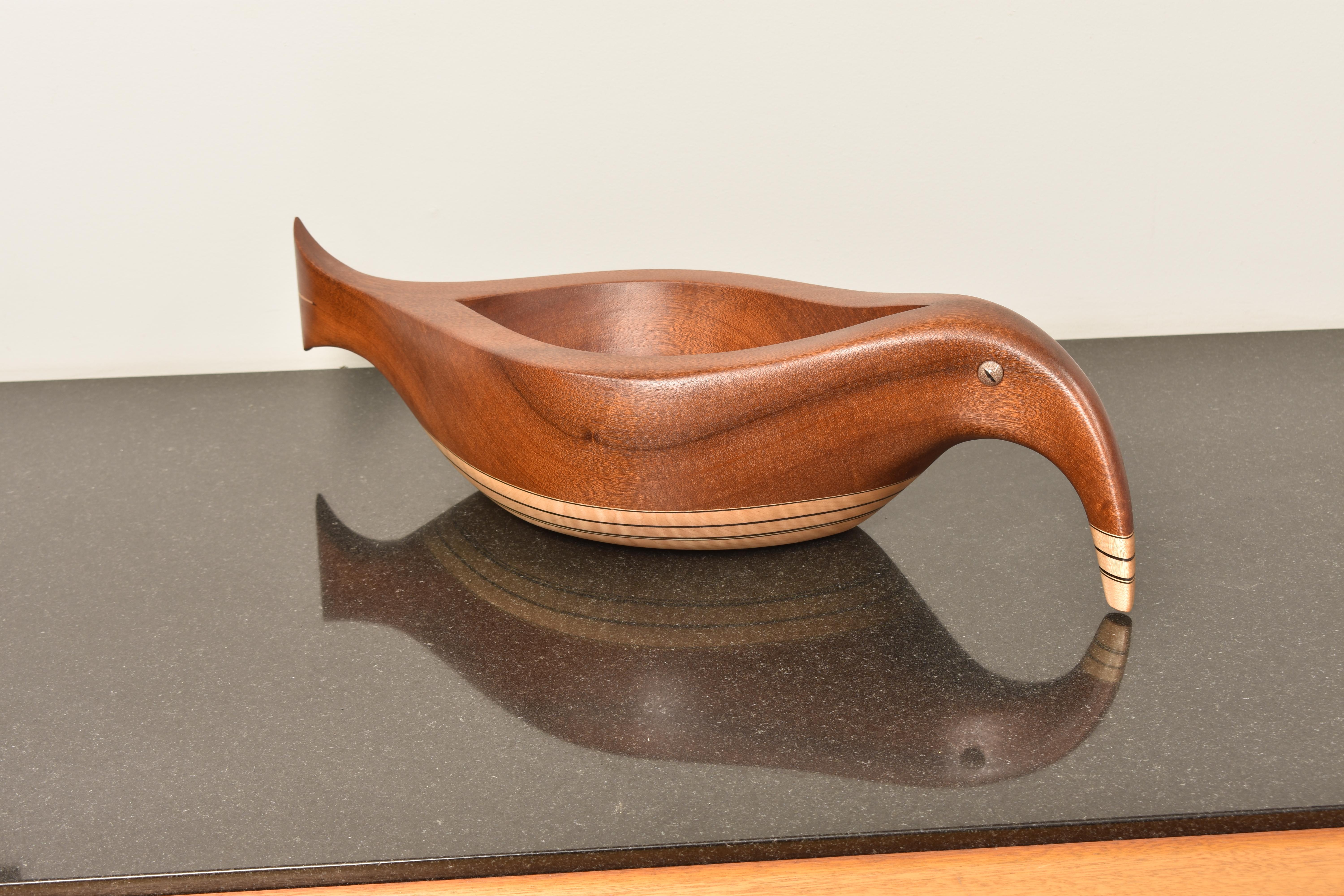 This hand sculpted one-of-a-Kind vessel is made of Sapeli wood with curly maple and ebony detailing. Glass reptile eyes. It is imagined as a combination between a fish and a bird. It is signed and dated and made by Lee Weitzman.