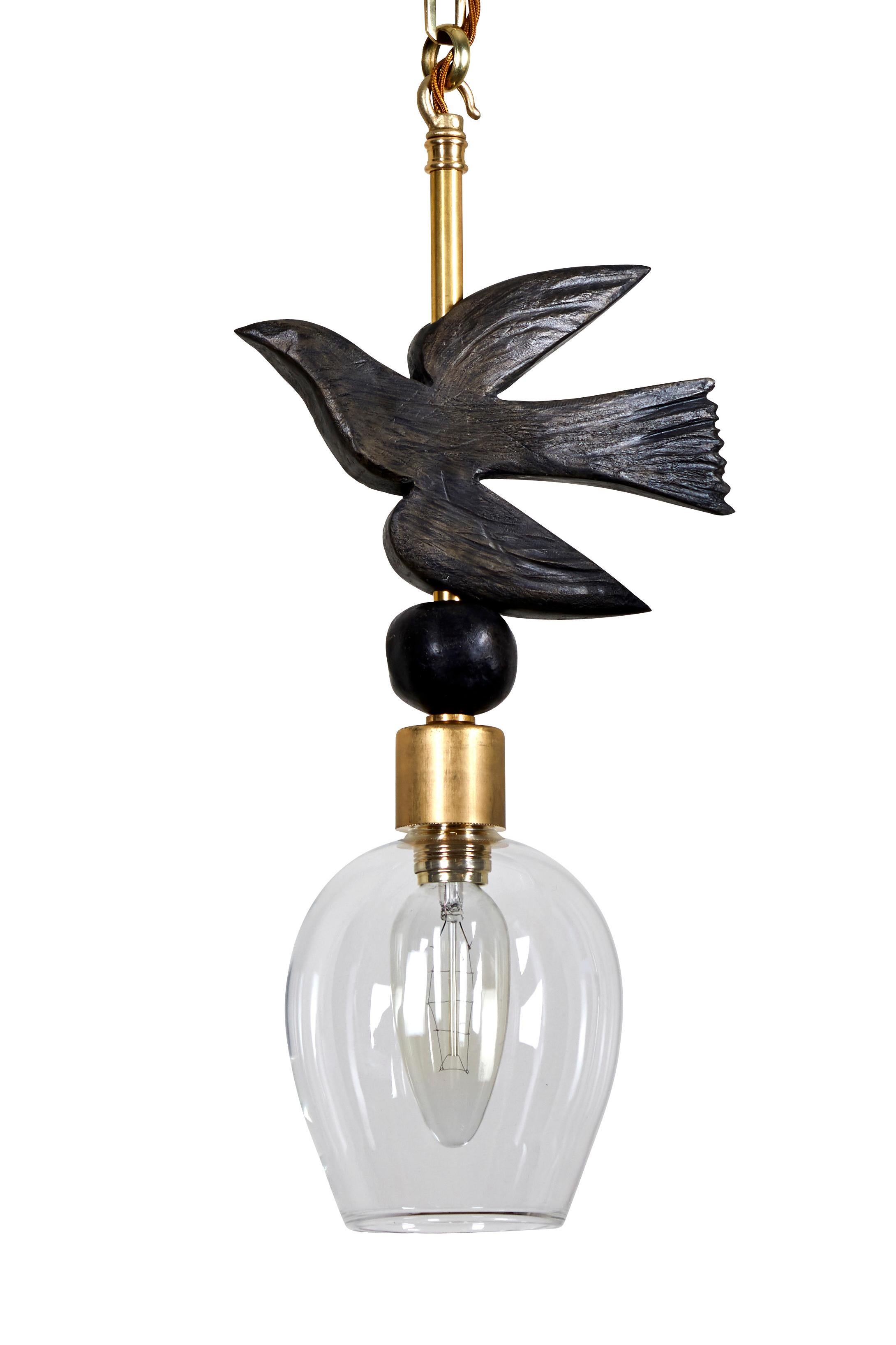 This Margit Wittig pendant (ceiling) light which features a bronze-resin pearl sitting below a hand-sculpted resin bird -in-flight cast in her London studio. The detail elements are hand-finished with a hint of gold patina to enhance the organic