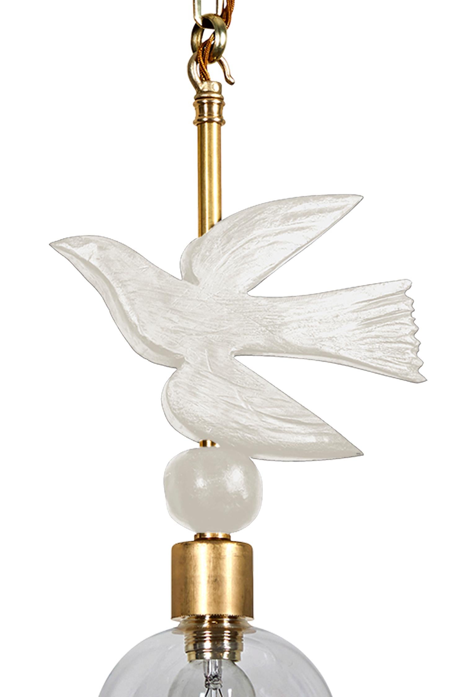 Ce luminaire suspendu (plafond) de Margit Wittig présente une perle en résine blanche sous un oiseau en vol en résine sculpté à la main dans son studio de Londres. Les éléments de détail sont finis à la main avec un soupçon de patine dorée pour