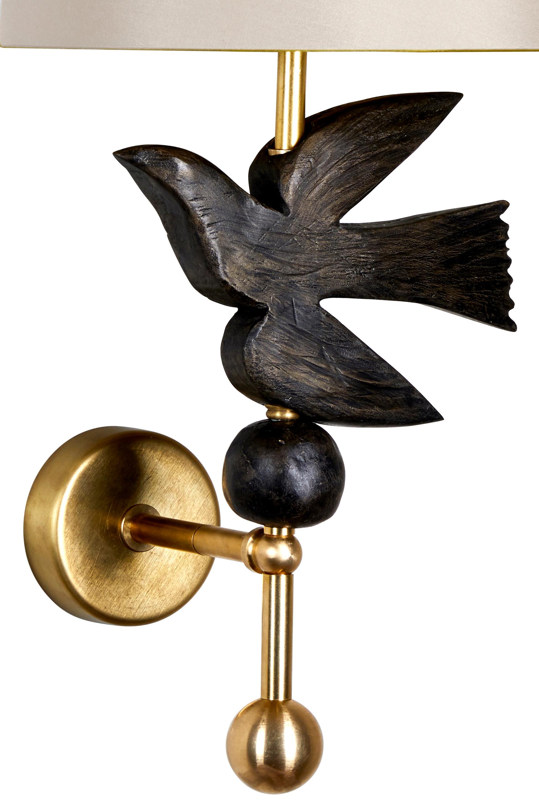 This Margit Wittig wall light (sconce) which features a bronze-resin pearl sitting below a hand-sculpted resin bird in flight cast in her London-based studio. The detail elements are hand-finished with a hint of gold patina to enhance the organic