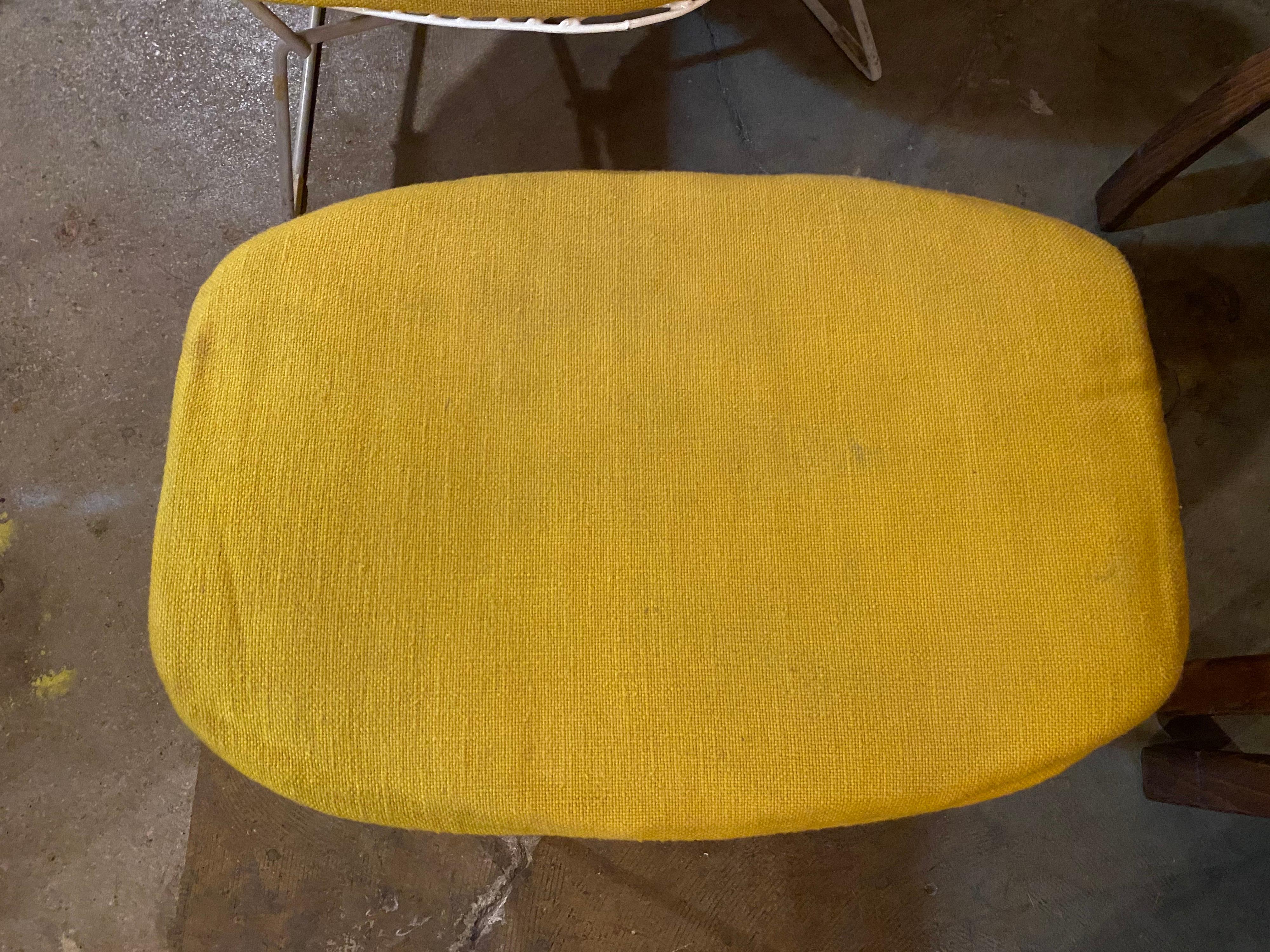 A classic mid-century design that is well-recognized, the bird chair and ottoman by Bertoia for knoll features a white finish and canary yellow cover. Circa 1960s, original foam has a crunchy feel and replacement is recommended; knoll tags attached.