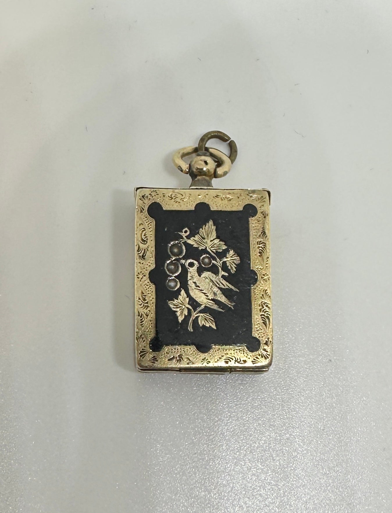 UN RARO CIONDOLO O CIONDOLO A FORMA DI ALBUM FOTOGRAFICO VITTORIANO IN ORO CON UN UCCELLO IN UN RAMO IN SMALTO NERO E ORNAMENTI IN PERLE.
Il medaglione è in oro 10 carati.  La balla grande è in oro 14 carati.  
Questo splendido medaglione ha la