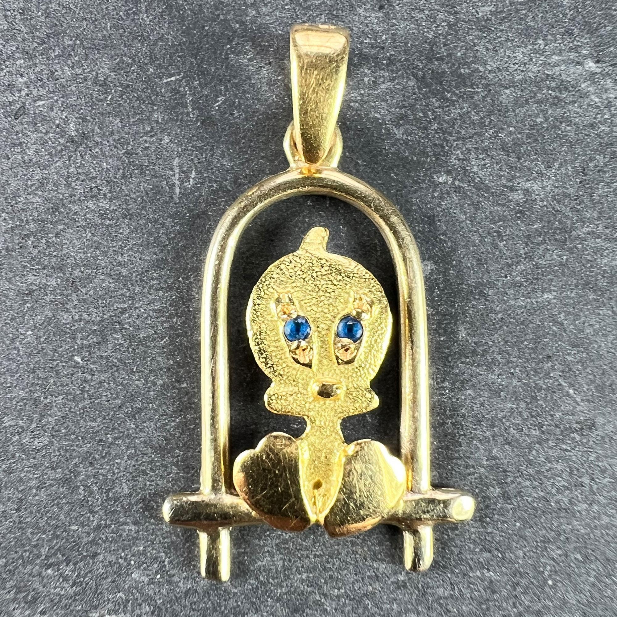 An 18 karat (18K) yellow gold charm pendant designed as a cartoon character bird on a perch with blue paste eyes. Stamped 750 to the pendant bail for 18 karat gold.

Dimensions: 2.4 x 1.5 x 0.25 cm (not including jump ring)
Weight: 1.61 grams
(Chain