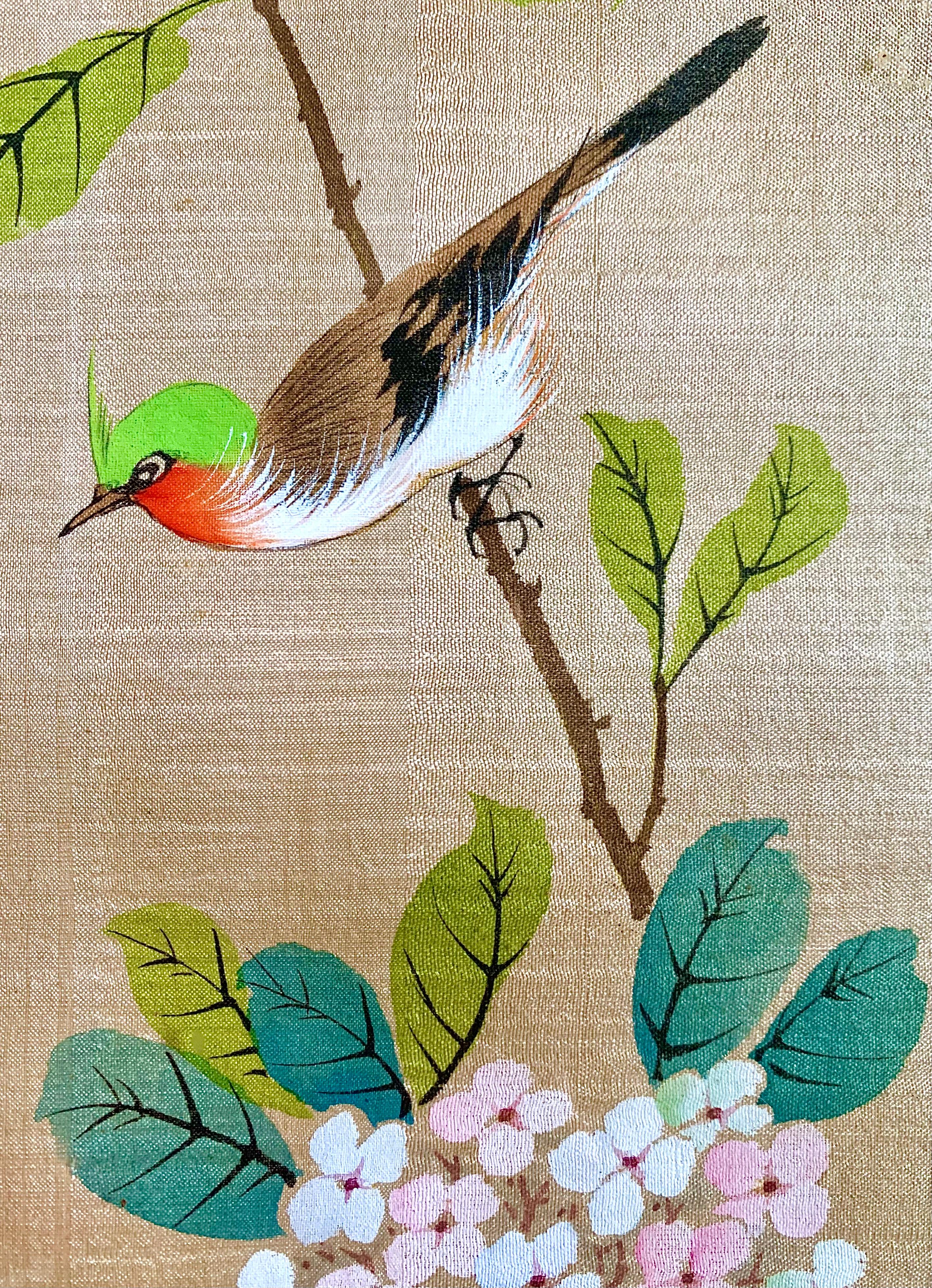 Nice painting on silk. It represents a bird, more precisely a woodpecker, on a branch with pretty pink and white flowers. The painted fabric is surrounded by another fabric with arabesque patterns. A Japanese writing is present in the upper right