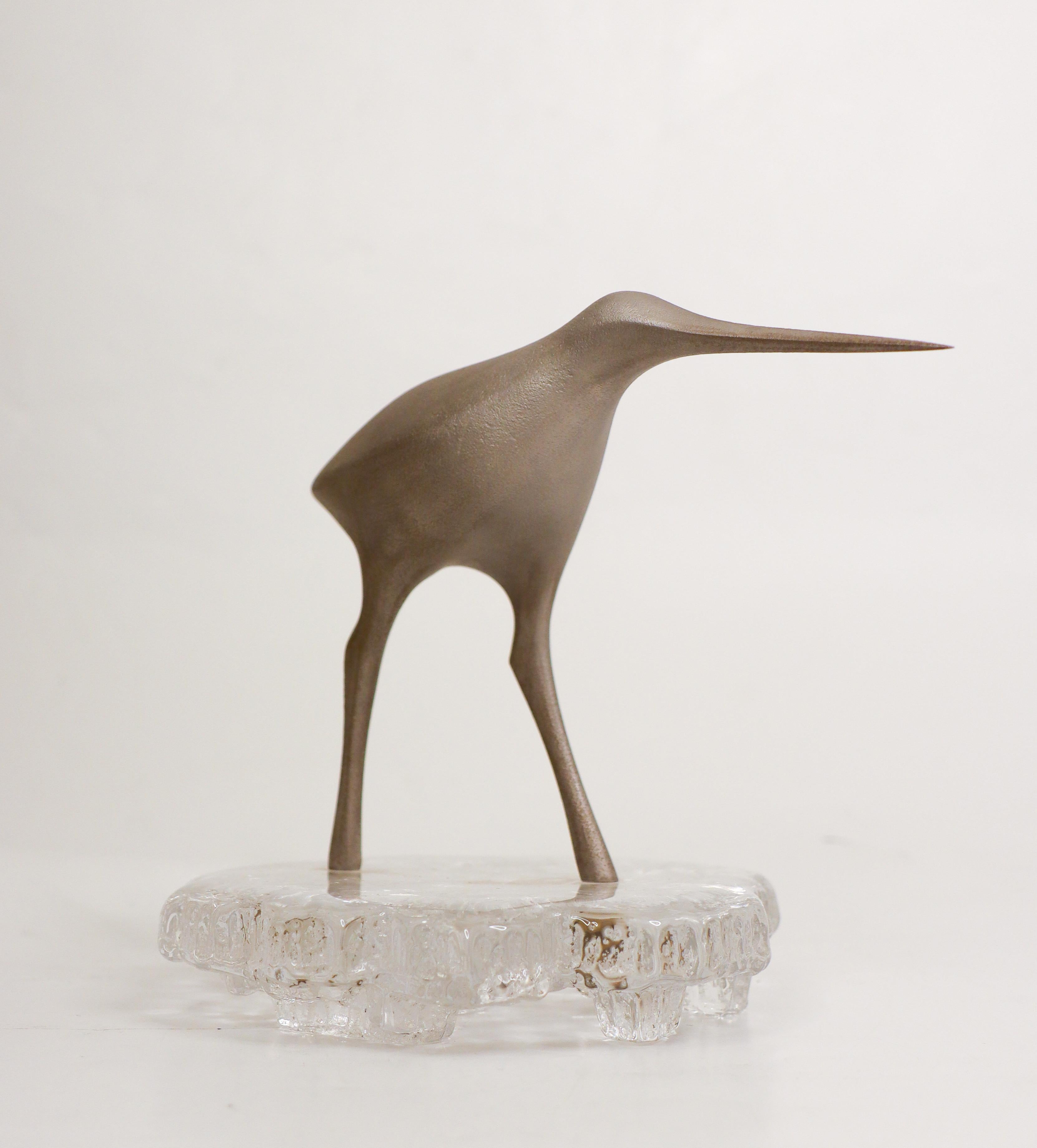 Eine schöne Vogelskulptur von Tapio Wirkkala. Sie besteht aus Metall mit einem Sockel aus Glas, ist 15,5 cm hoch und hat einen Durchmesser von etwa 13,5 cm an der Basis. Der Metallteil ist gestempelt, und der Glassockel ist unten signiert. Der