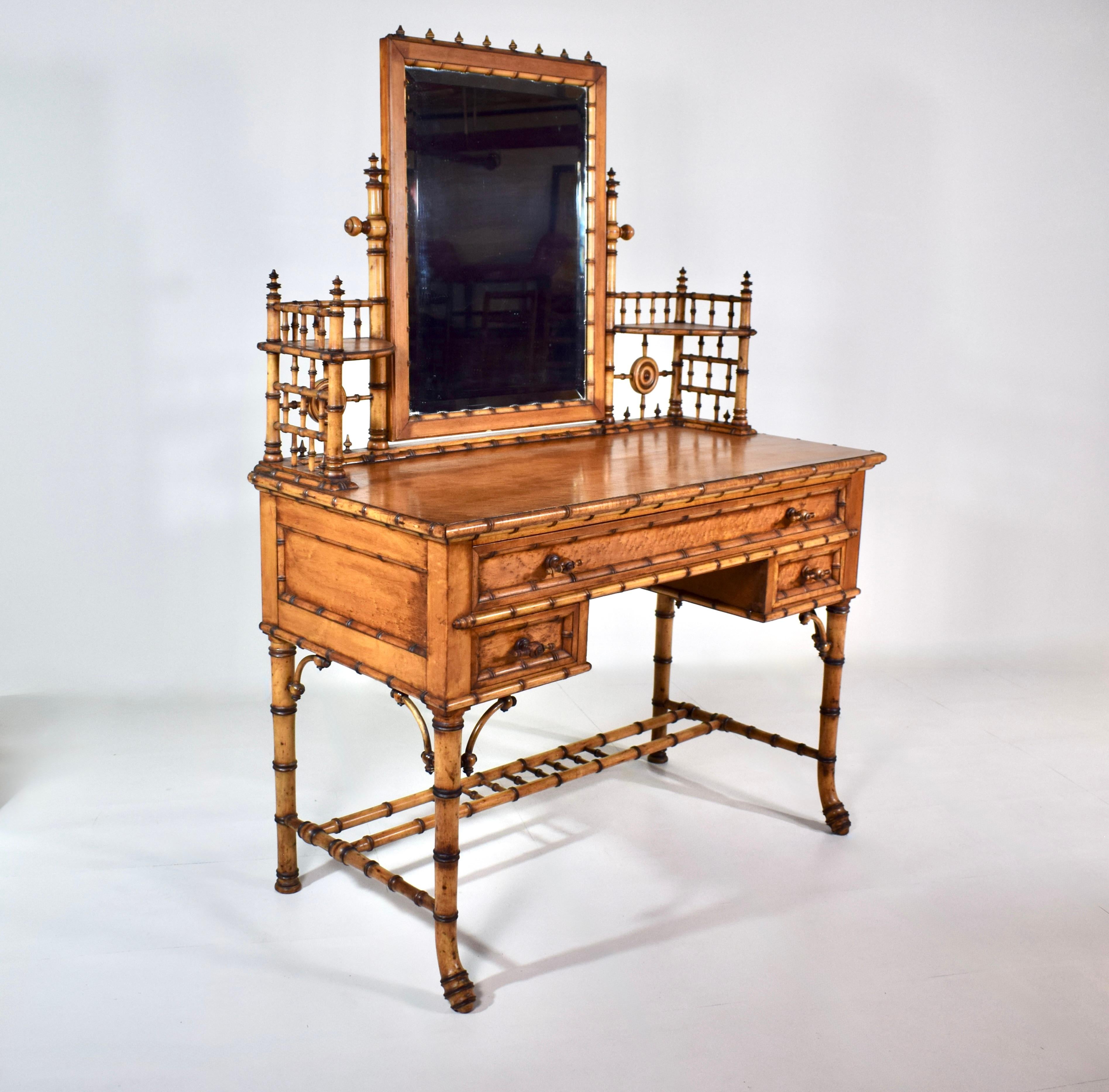 Part of a rare seven-piece collection of American Aesthetic Movement Birdseye Maple faux bamboo bedroom furniture. The dressing table features one large top drawer and two smaller drawers. The original rectangular beveled mirror pivots & can be
