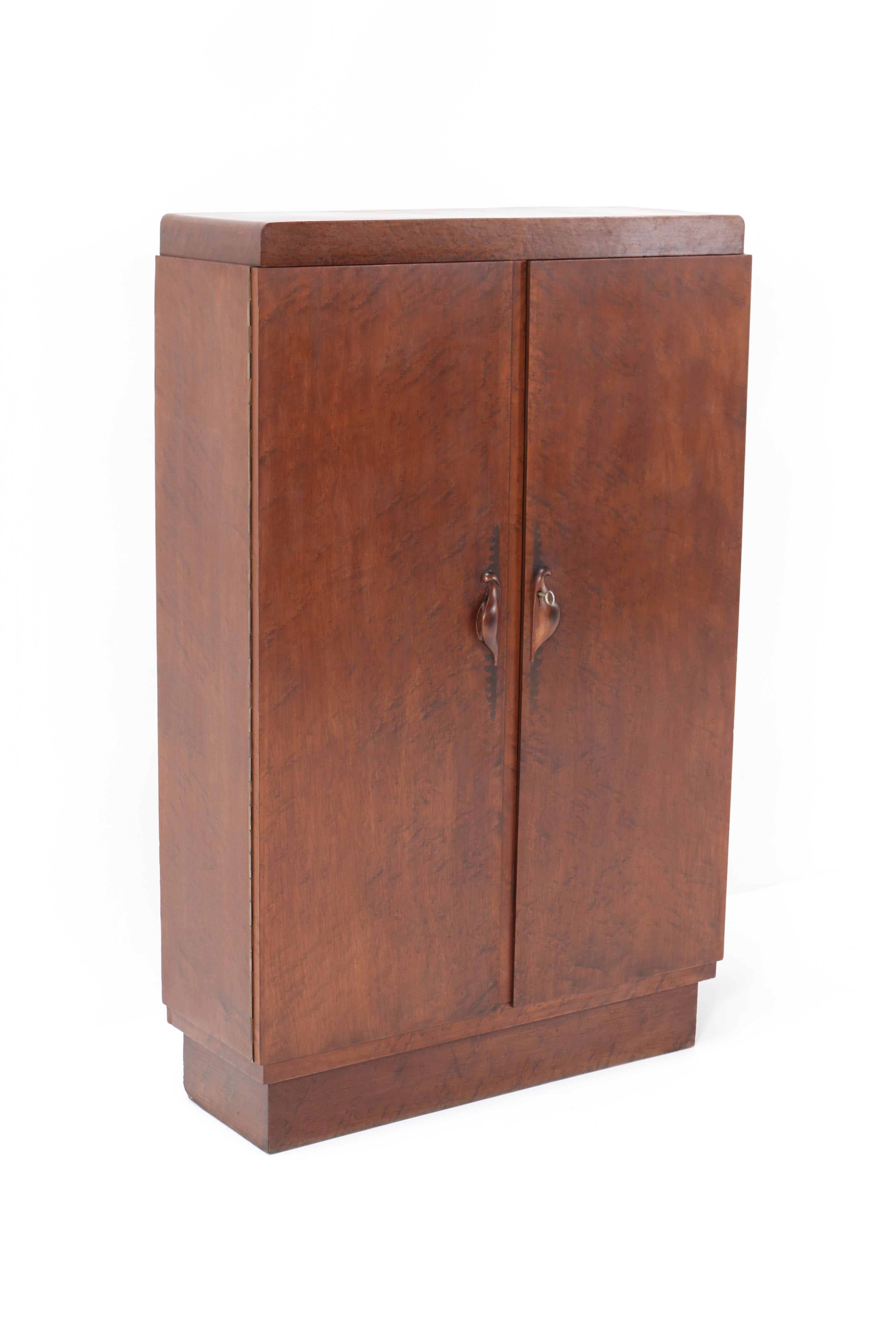 Stunning and rare Art Deco Amsterdam School cabinet.
Design by 't Woonhuys Amsterdam.
Striking Dutch design from the twenties.
Birdseye Maple with magnificent shaped handles on both doors.
In very good original condition with minor wear