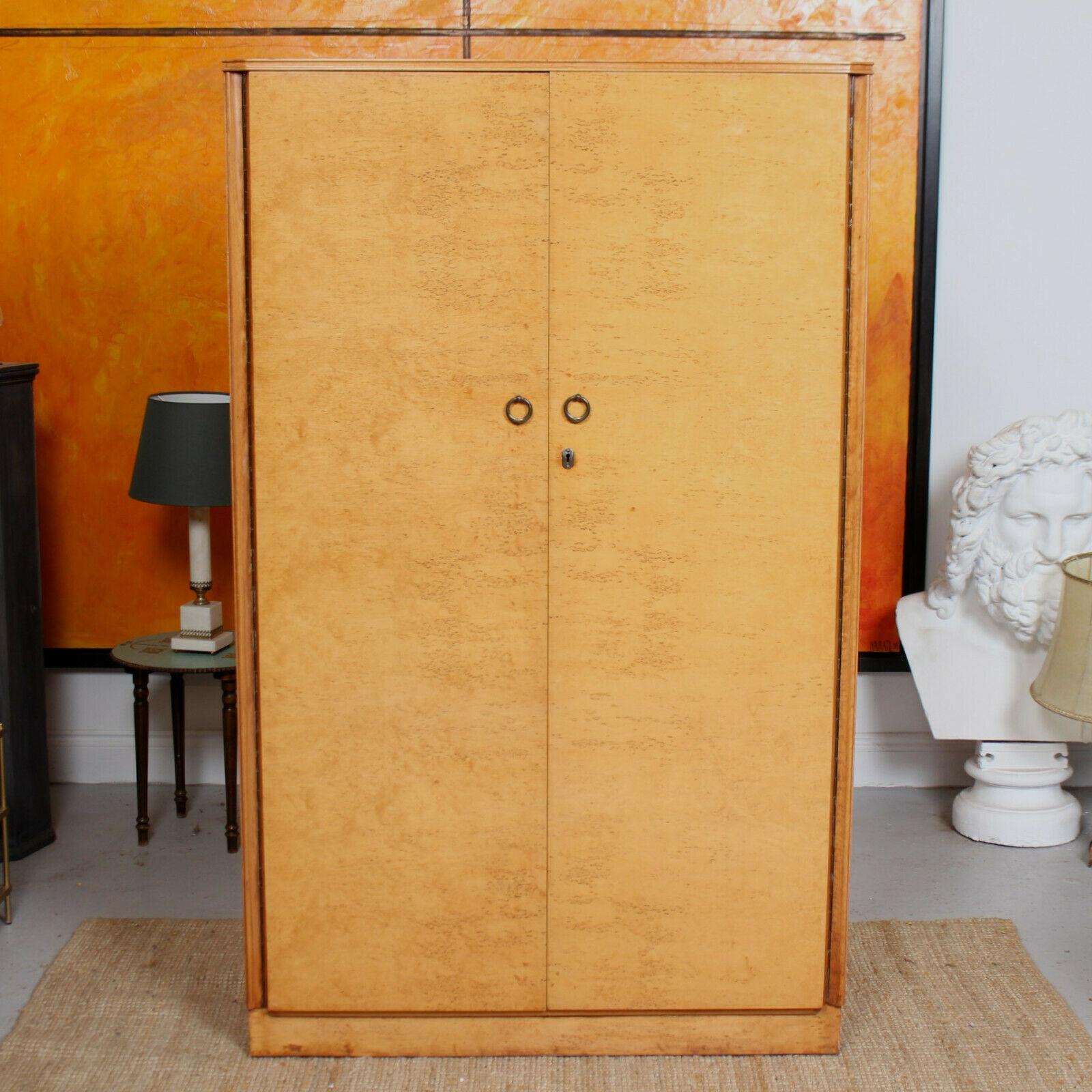 A fine quality bird's-eye maple compactum wardrobe.
The double doors enclosed a mahogany lined fitted interior comprising tie rack, hanging rail, shelving, drawers and footrails. Raised on a plinth base.
England, circa 1950.