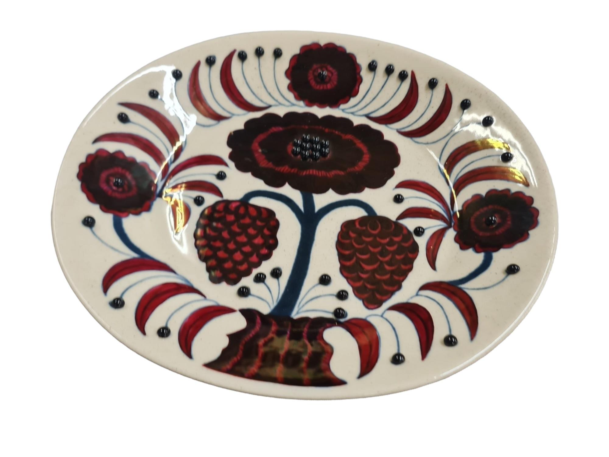 Beautiful ceramic plate decorated with multiple beadings.  Back of the plate is signed 
