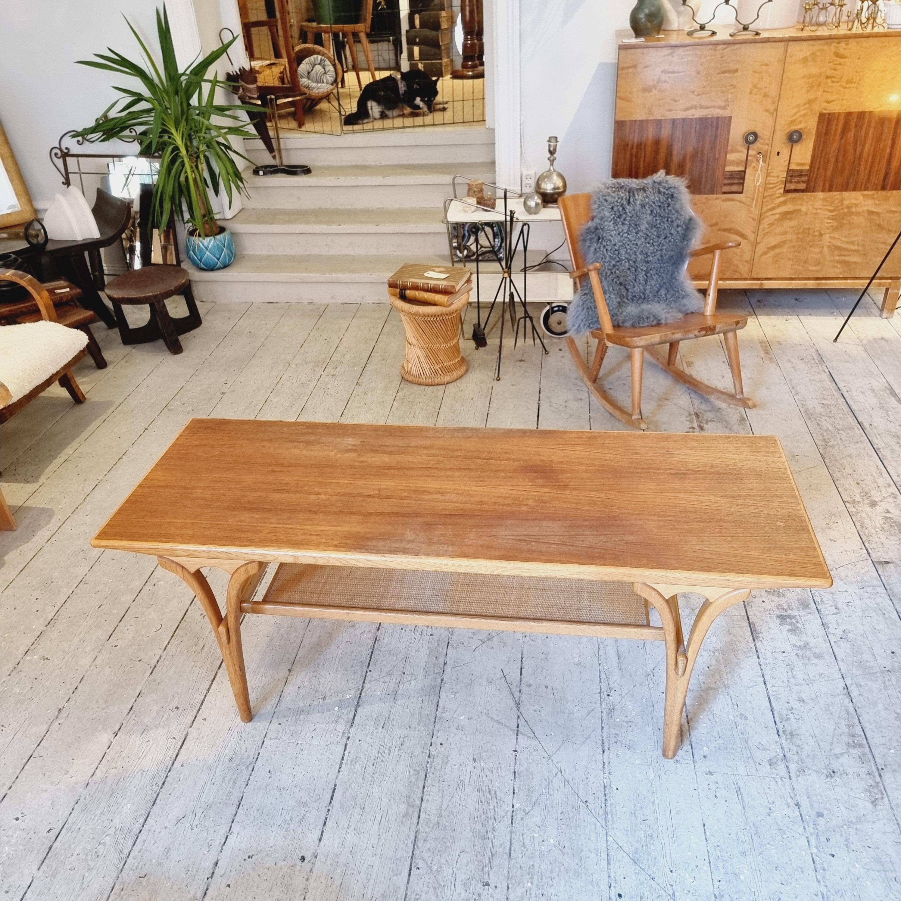 Coffee / sofa table in teak with oak ledge and shelf in rattan. Made by Birger Larssons Möbelfabrik, Bodafors, Nässjö. Sweden 1960s. 

With label. In good condition. table top and legs with normal signs of age and wear. 