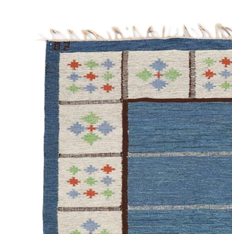 Midcentury Swedish rug, hand woven wool, flatweave ‘röllakan’ by Birgitta Södergren. Pattern in grey, blue center field and edges, decorated square surfaces, 240 x 173 cm. Signed “BS”.

Halv-flossa or relief-flossa—translated half pile or relief