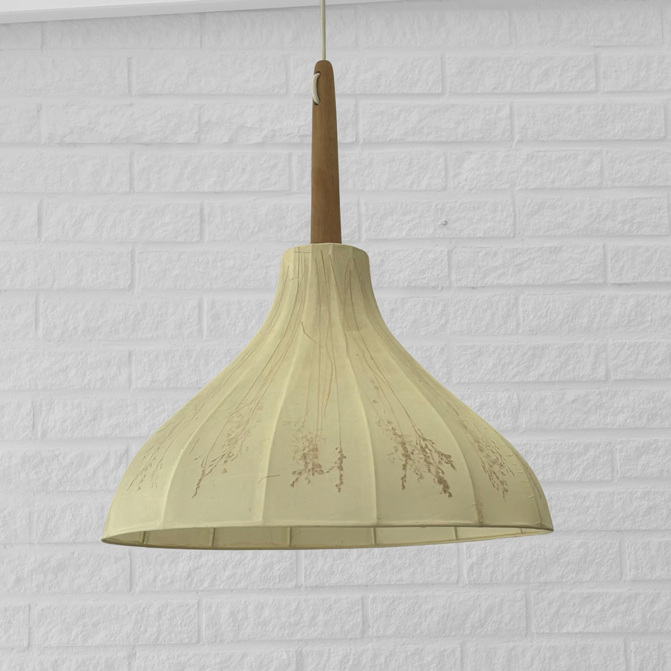 A beautiful Swedish Arts and Crafts pendant lamp, Kjolen (The Skirt), designed and handcrafted in the 1950s by Birgitta Sorbon Malmsten, daughter-in-law of renowned architect Carl Malmsten. The shade features a white metal frame covered in