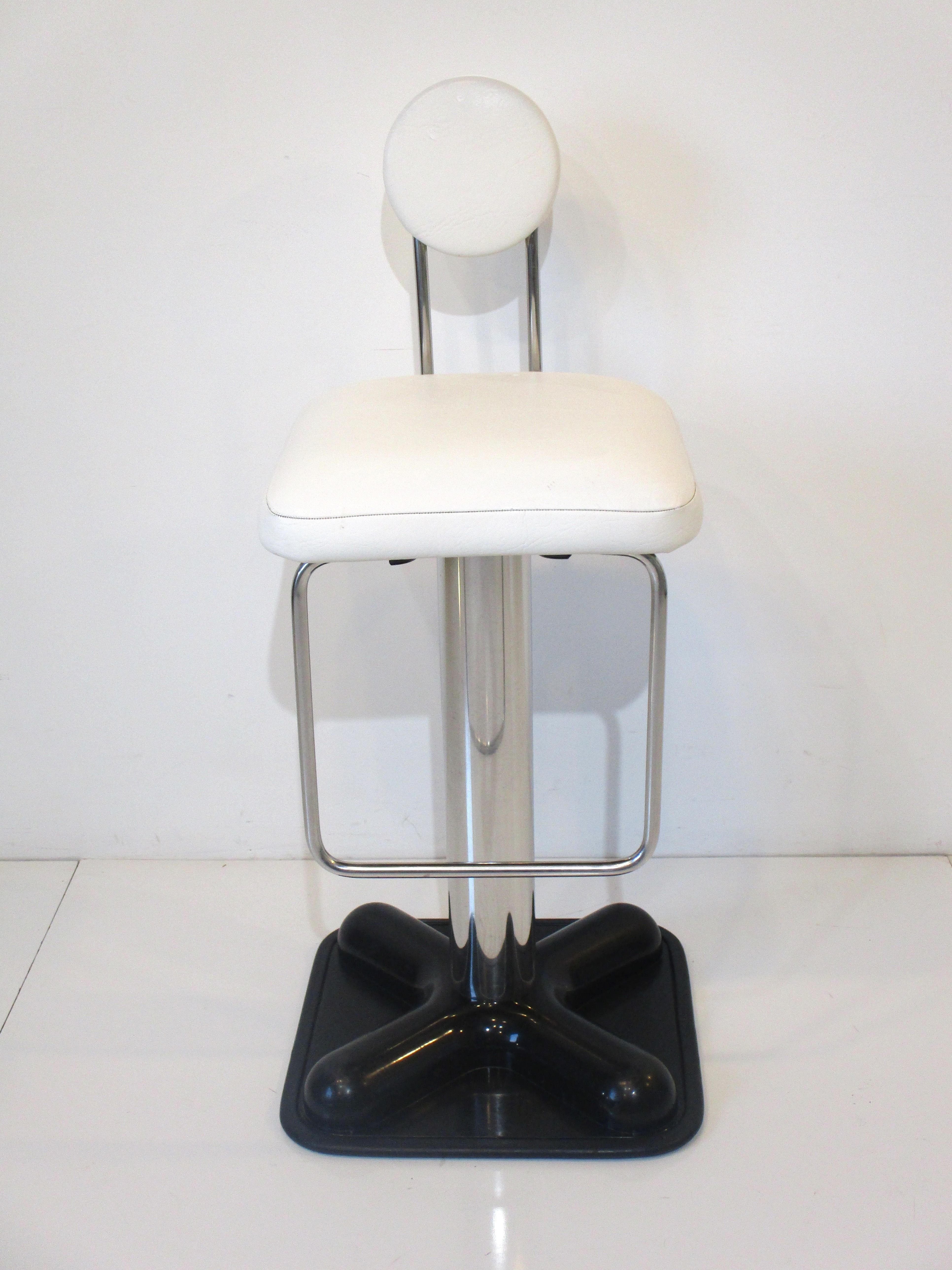 A mod pop art bar or counter Birillo stool by iconic Italian designer Joe Colombo with square seat bottom and lollipop styled seat back in white vinyl . Having a heavy duty chromed metal pole shaft with foot rest sitting on a satin black ABS molded