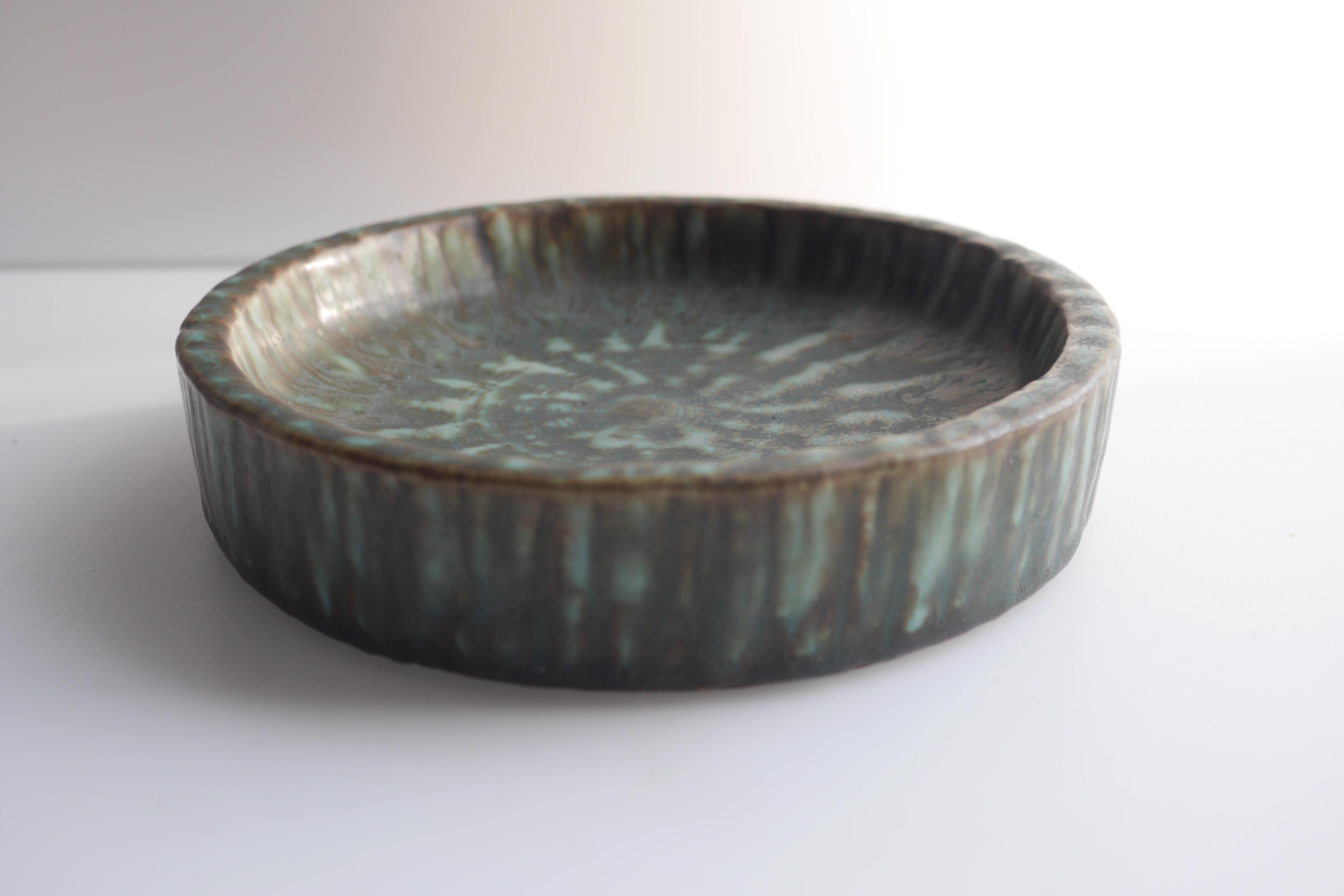 From Gunnar Nylund's 'Birka' series för Rörstrand, this beautiful shallow bowl has a subtle pale blue and brown textured glaze. This piece is in perfect condition. 

The Birka series included bowls, vases and pots and had three different glazes for