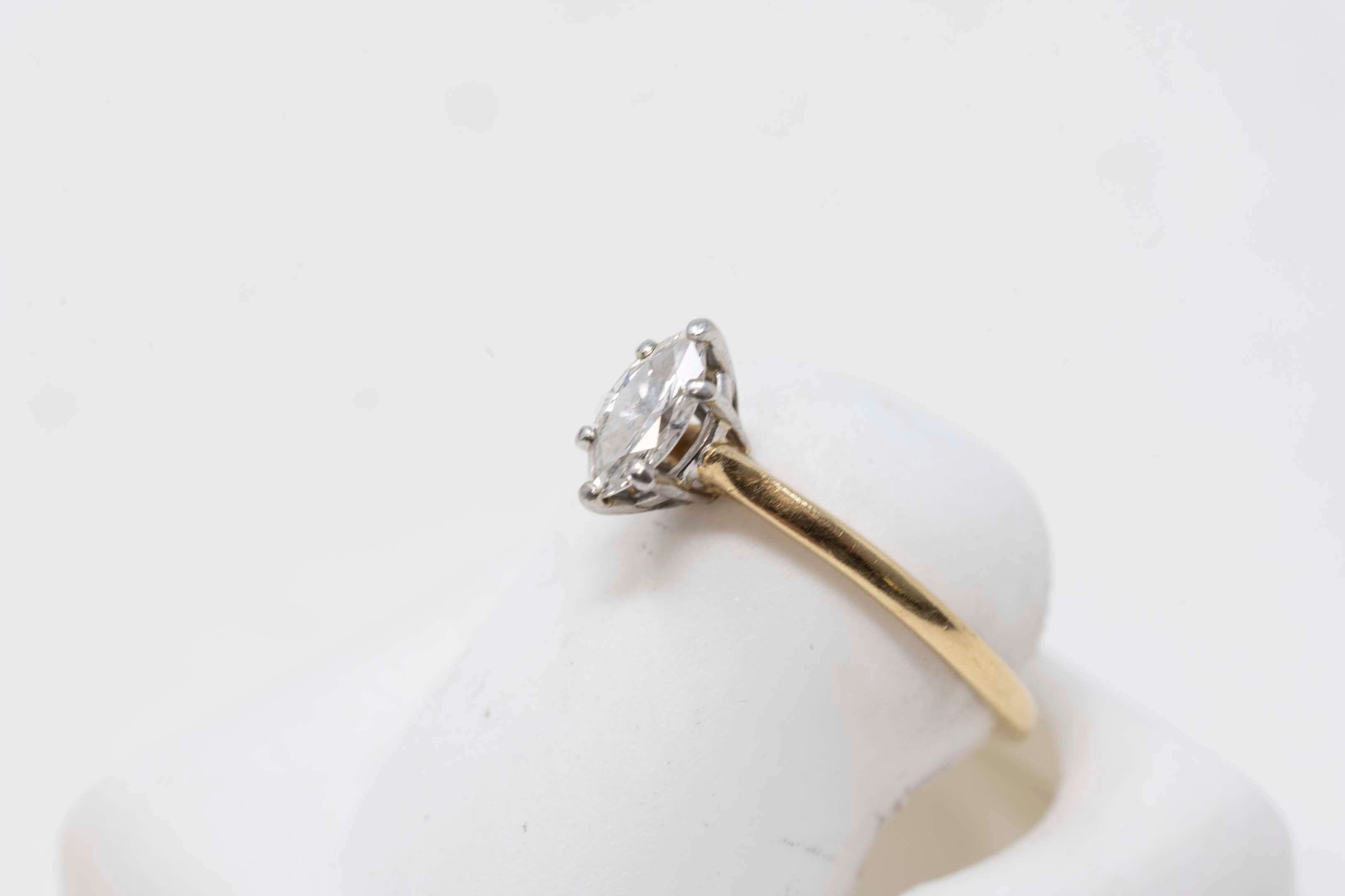 Ladies ring in 18k yellow gold and platinum (stamped) modern style, solitaire model, plain finish. Size 7.75, makers mark Birks, total weight of ring 2 grams. The ring is set with one marquise shaped brilliant cut diamond. Weighs approximately .35