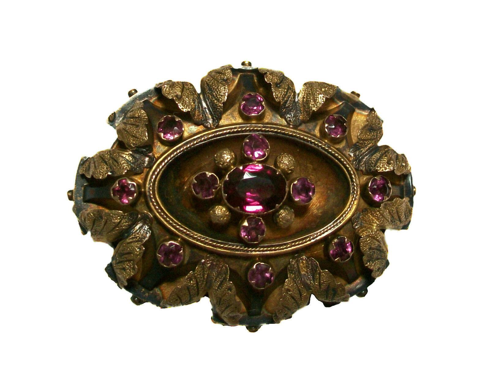 BIRKS (1879-Present) - Antique 14K yellow gold oval brooch - set with one large oval faceted purple Tourmaline (approx. .56 carats - 6.5 x 5 x 3 mm.) - surrounded by 12 small round faceted purple Tourmaline (well matched - 2 mm. diameter - approx.