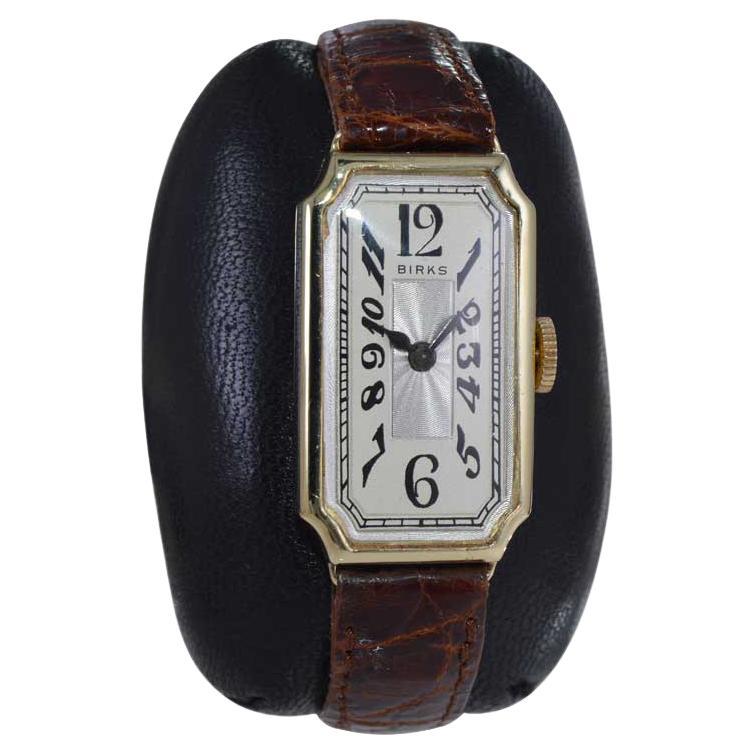 FACTORY / HOUSE: Birks of Canada
STYLE / REFERENCE: Art Deco Tank Style 
METAL / MATERIAL: 14kt Solid Gold 
CIRCA / YEAR: 1930's
DIMENSIONS / SIZE: Length 34mm x Width 18mm
MOVEMENT / CALIBER: Manual Winding / 15 Jewels 
DIAL / HANDS: Silvered with