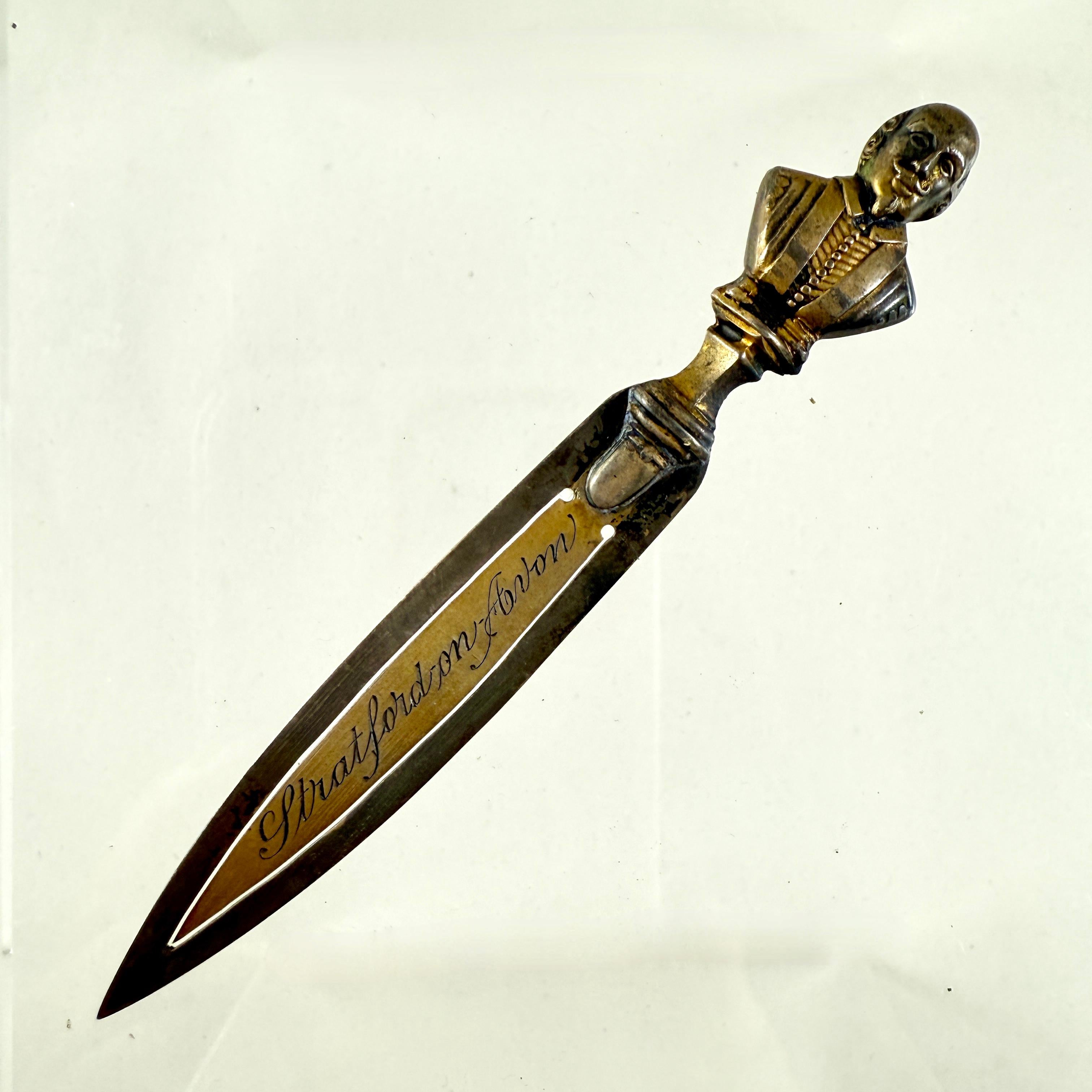 A brass letter knife or bookmark, made by George Unite, Birmingham, England, date marked 1902.

The head of William Shakespeare, the English playwright, poet, and actor is cast in the round at the terminal of the knife.

Shakespeare is widely