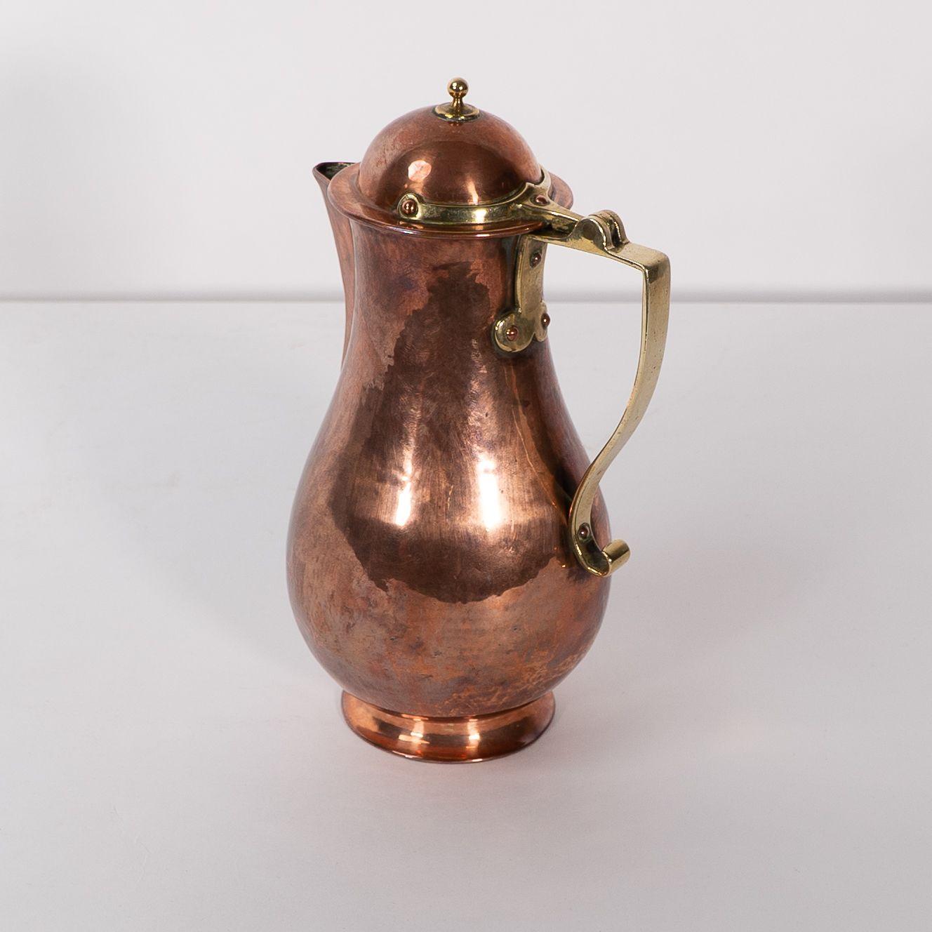Early 20th Century Birmingham Guild of Handicraft. An Arts & Crafts copper and brass chocolate jug For Sale