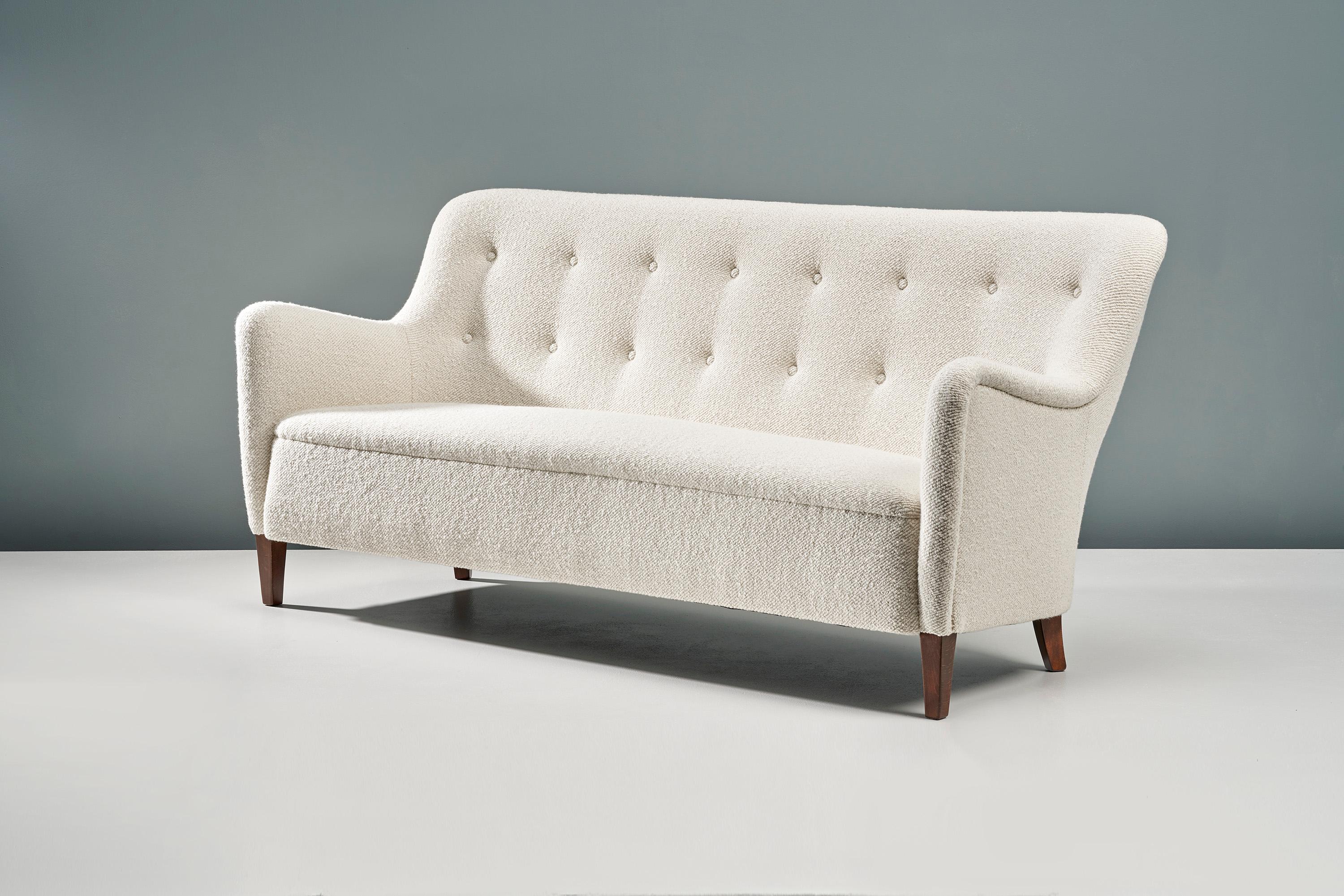 This exceptional piece of Danish furniture was designed in the 1940s by designer Birte Iversen and produced by master cabinetmaker A.J. Iversen. This example has been reupholstered in luxurious cotton-wool blend boucle fabric from Dedar Milan at our