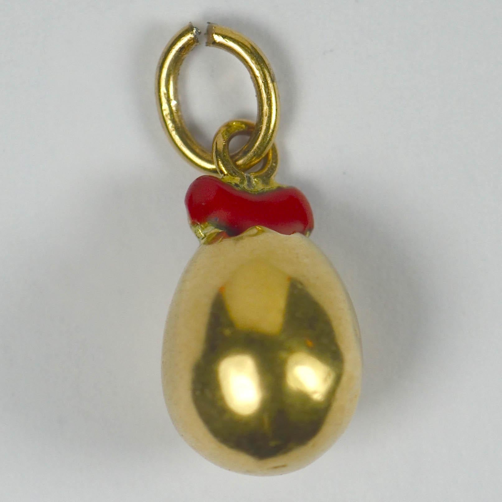 French charm pendant depicting the birth of love as a red enamel heart emerging from a broken 18 karat yellow gold egg. 1/2