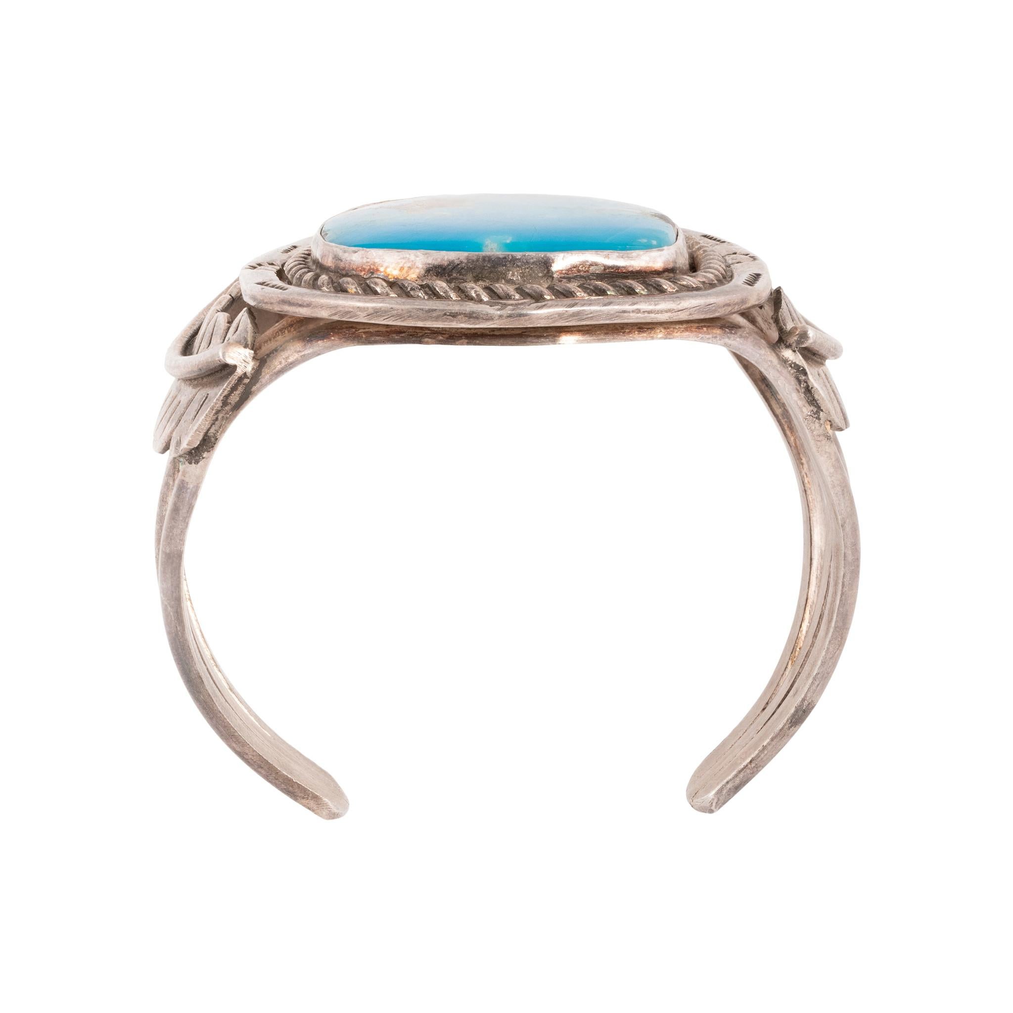 Bracciale in turchese Bisbee e argento sterling. Bellissima pietra Bisbee di grandi dimensioni con castone incastonato al centro, di colore blu intenso e matrice di quarzo. Corda intrecciata e bordo stampato a mano, lati incorniciati da piume in