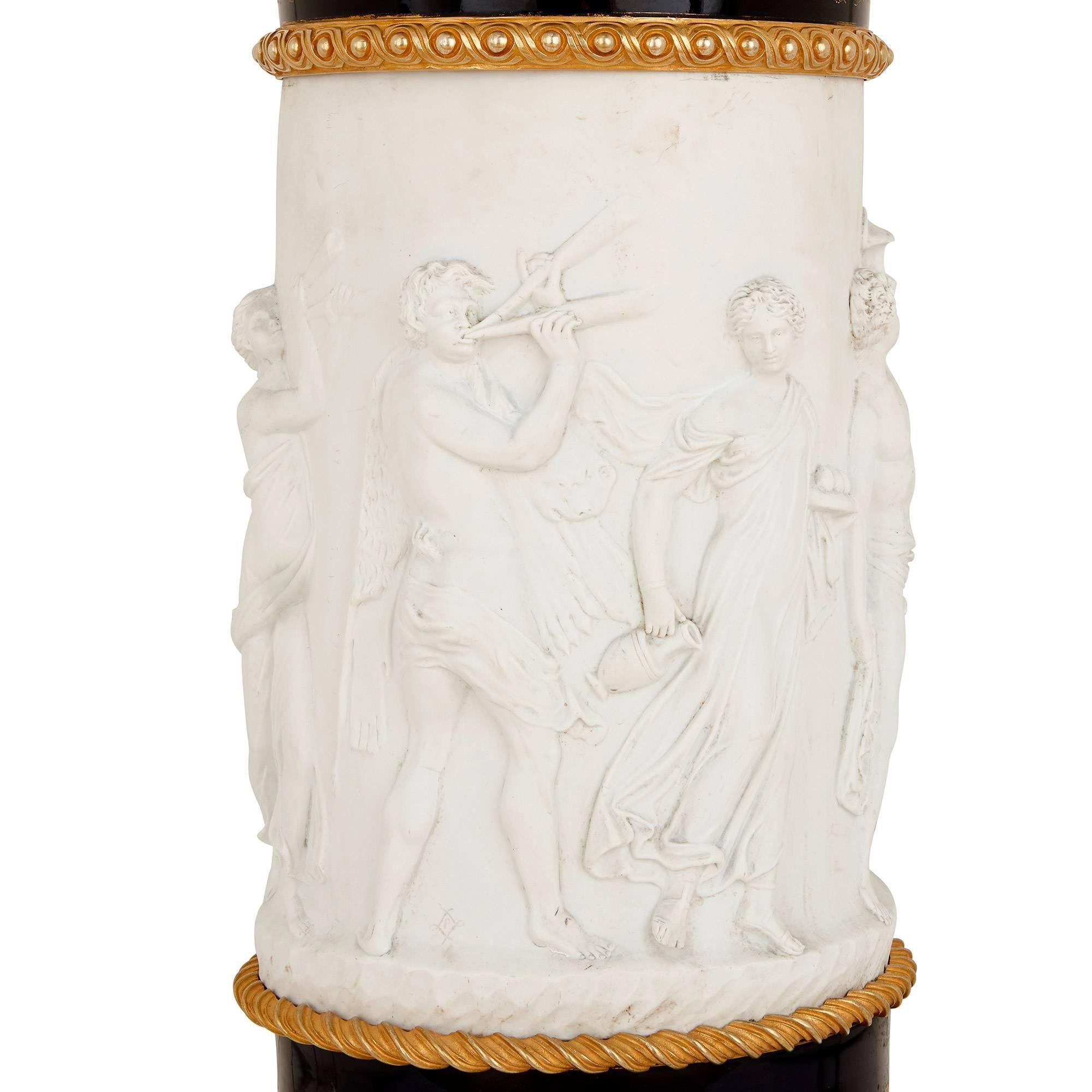 This unique pedestal is crafted from a combination of glazed and unglazed porcelain, mounted elegantly with gilt bronze. The unglazed porcelain - known as biscuit (or bisque) porcelain - is white in colour and has a matte finish, contrasting