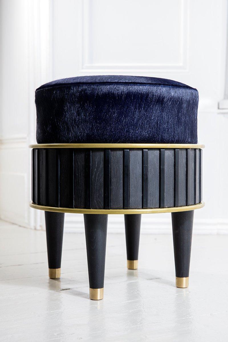 The bisi stool is constructed from blackened oak, liquid and solid brass, corian and is upholstery in a hair on cowhide.

The stool can be upholstered in the material of your choice (material chosen may impact on cost).