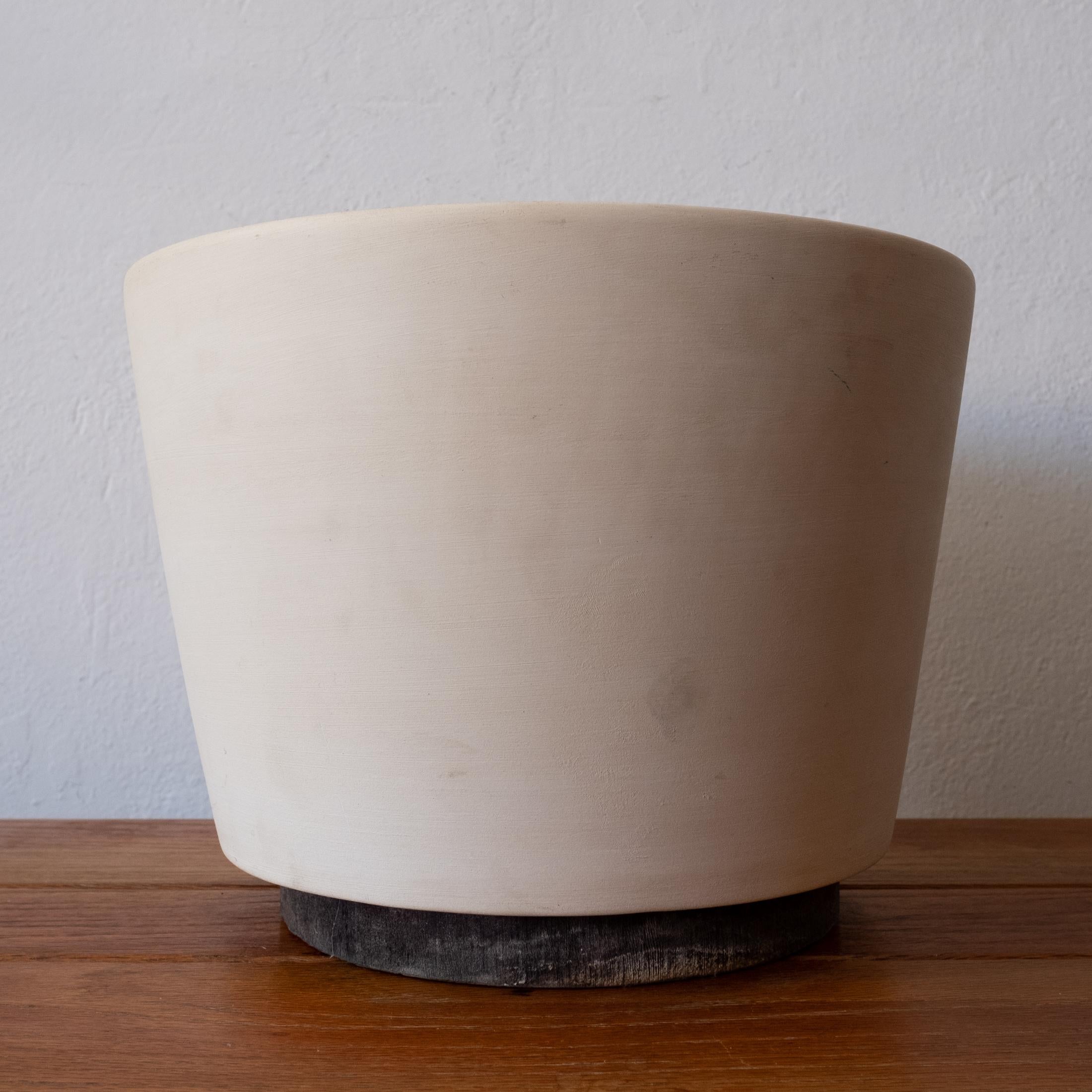 Architectural Pottery planter by Malcolm Leland in bisque. Original redwood foot. Not drilled so it would work great indoors or outside. Architectural Pottery is the epitome of California Mid-Century Modern design.