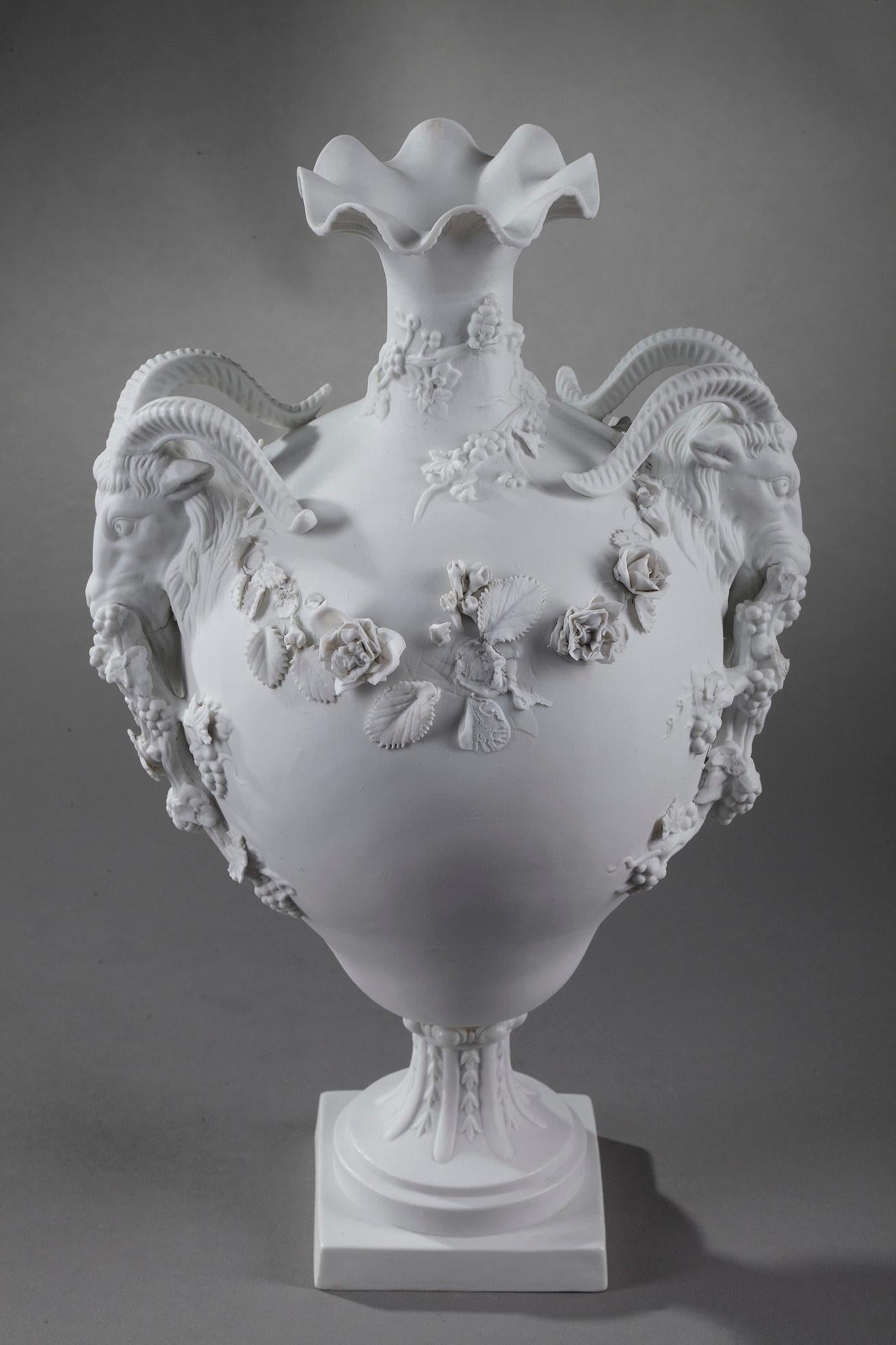 Porcelain bisque vase with poly-lobed neck, the handles decorated with goats holding bunches of grapes in their mouths, after a model close to Duplessis called Goat's Head. The vase is highlighted with garland of roses and grapes. Sevres apocryphal