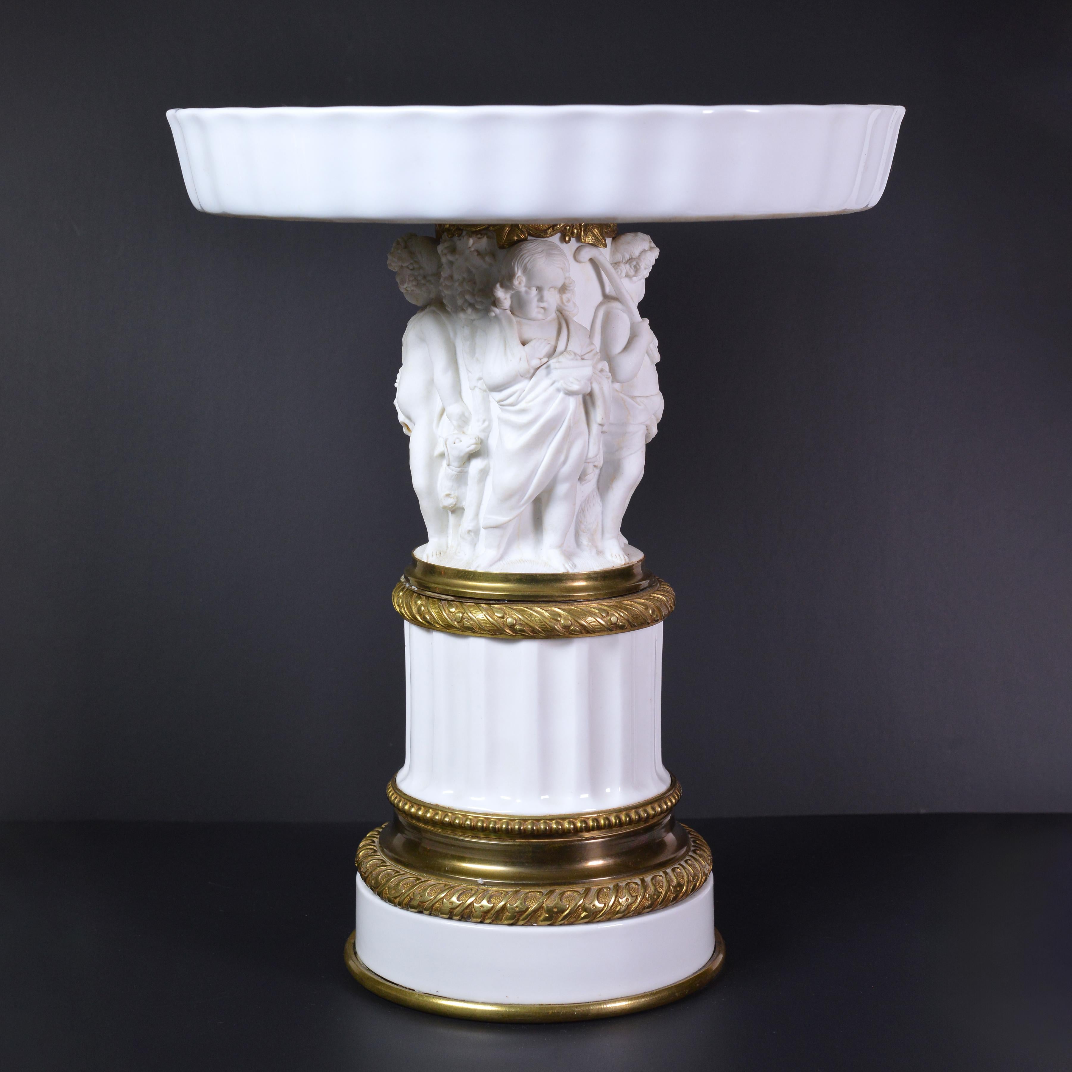 Vase Empire (Tazza) produit en porcelaine biscuit par une manufacture de haut niveau, probablement en Allemagne ou en France, dans la seconde moitié du XIXe siècle et décoré de détails en bronze doré finement travaillés. Grande allégorie représentée