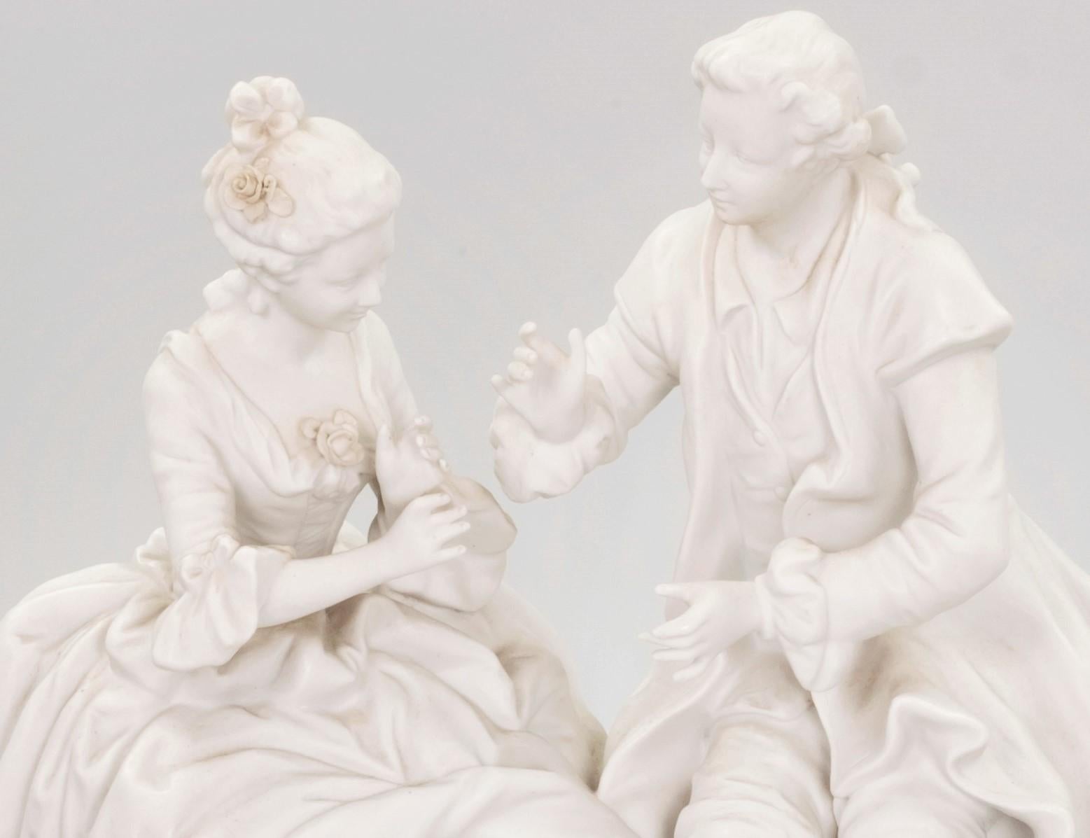 Figurine en porcelaine biscuit française du 19e siècle représentant un couple assis et engagé dans une conversation. La figurine est marquée au dos et numérotée 