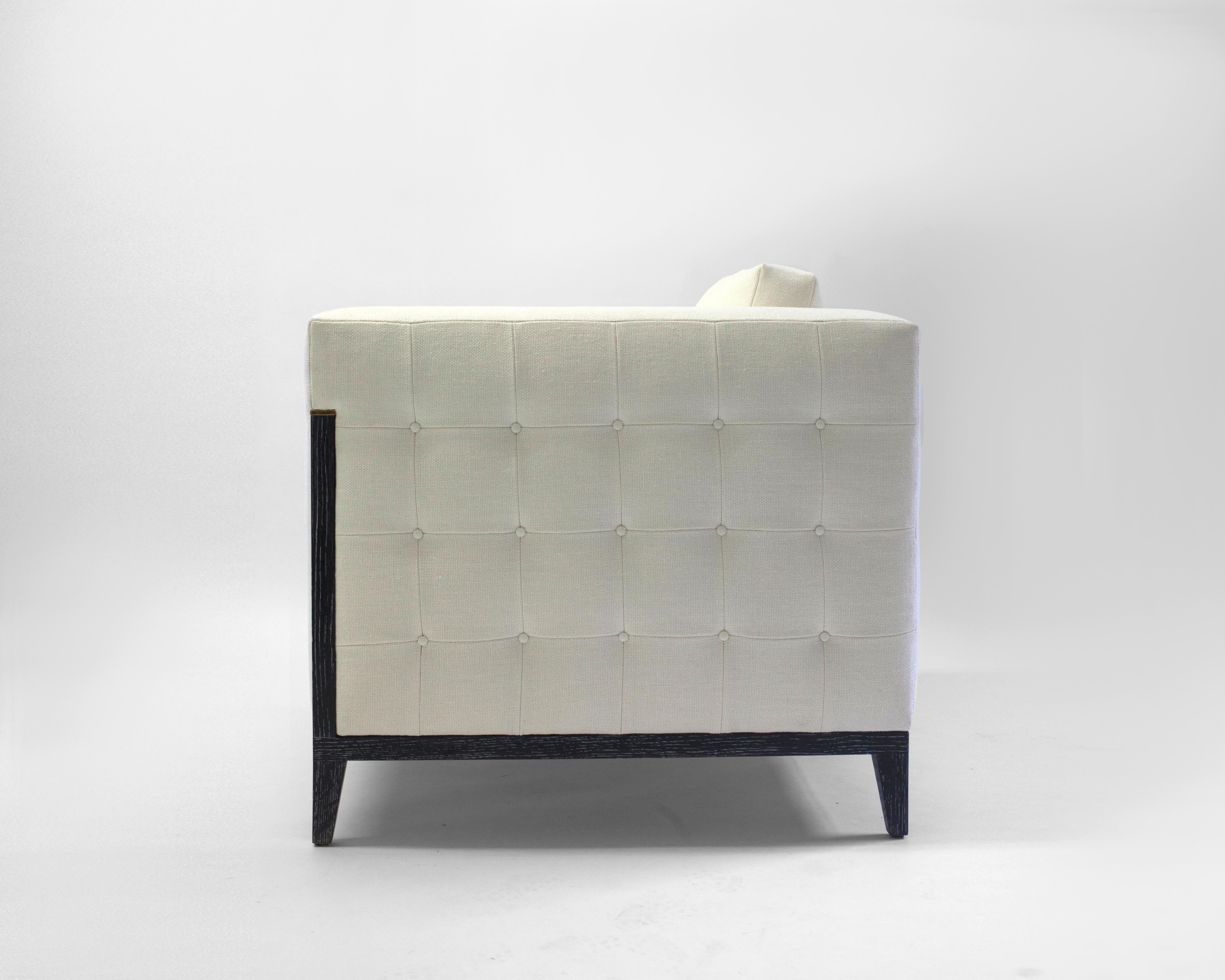 Der Klubsessel Milton von LF Upholstery ist eine schlichte, moderne Variante des alltäglichen quadratischen Sessels, mit losen Rücken- und Sitzkissen mit weicher Schaumstoff-, Feder- und Daunenfüllung, abgebildet mit Holzdetails entlang des Rahmens,