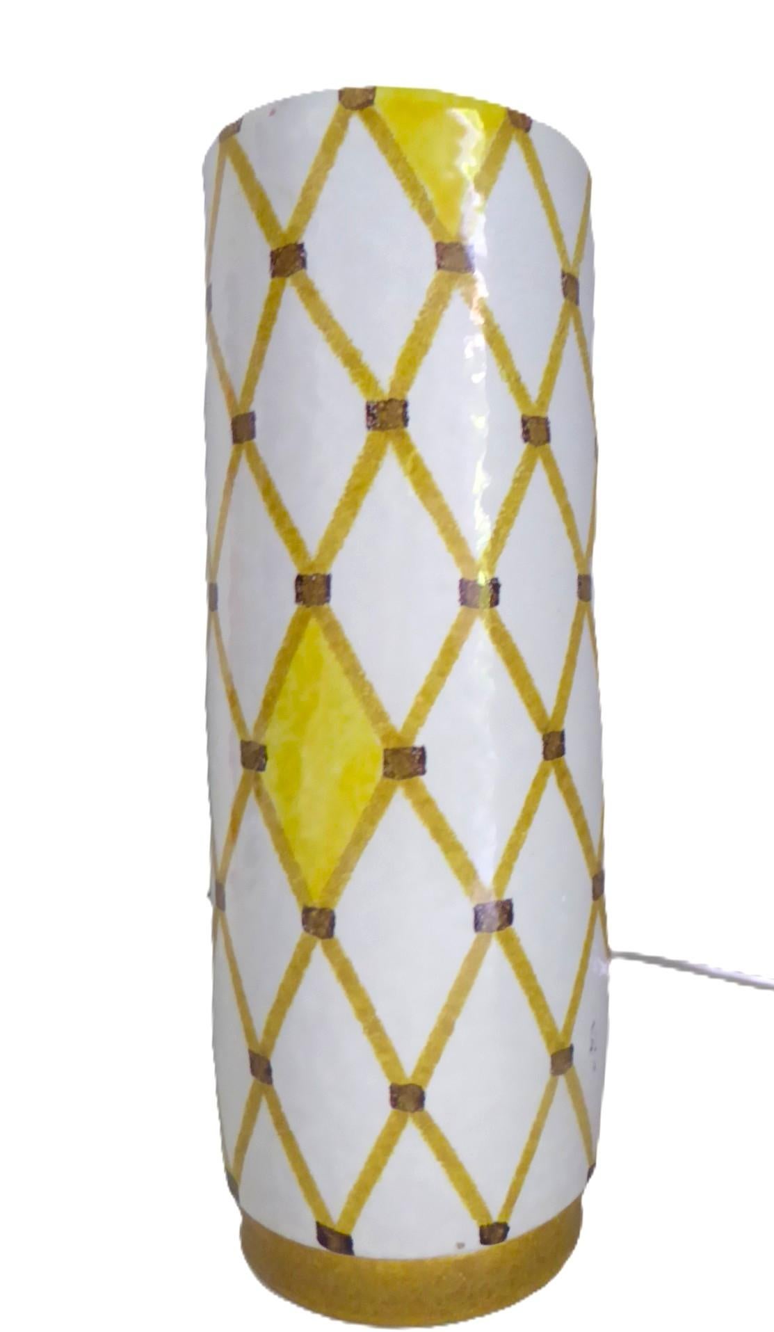 Schöne große zylinderförmige Bitossi cremefarbene Vase. Mit einem braunen Spalier- oder Fischnetzmuster mit einigen hellgelben Feldern über einer weißen Glasur auf einem niedrigen, senfglasierten Sockel.
Auf dem Boden mit schwarzer Unterglasurfarbe