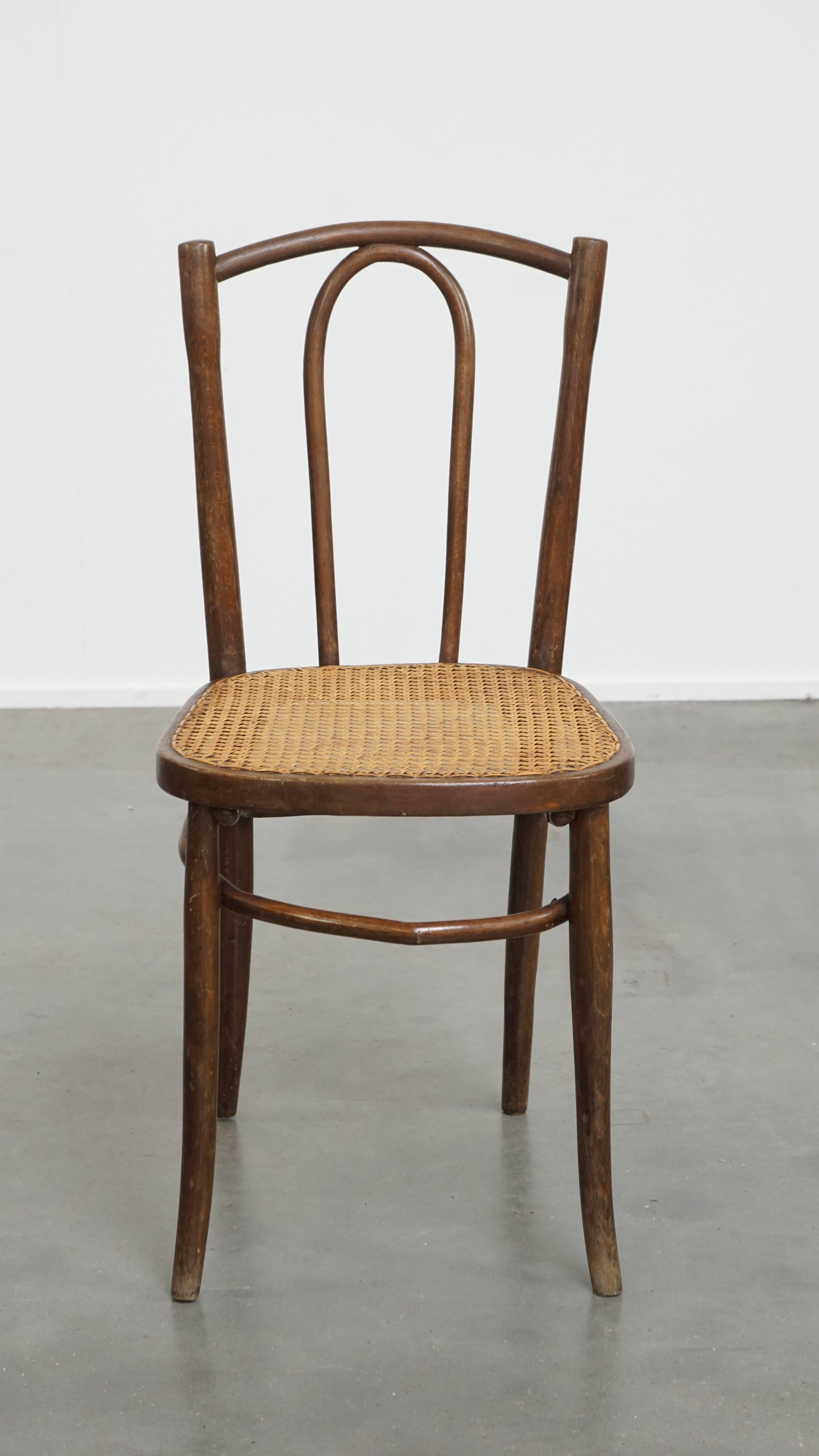Offered here is this charming, timeless bistro chair in the style of Thonet with a woven cane seat. This elegant bistro chair, crafted with a wooden frame, features a woven cane seat. It can be easily placed in virtually any interior and space of