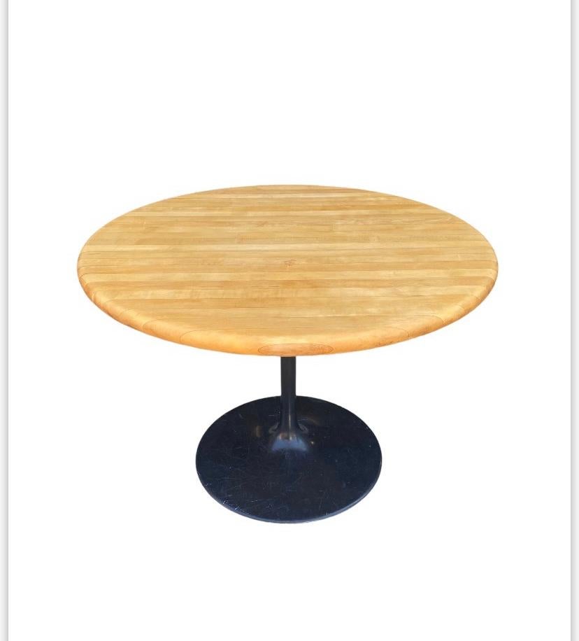 Vintage butcher block dining table. Done in the style of Saarinen with the iconic black lacquer metal base. A modern take on a classic design. Measure: 42 inches round.