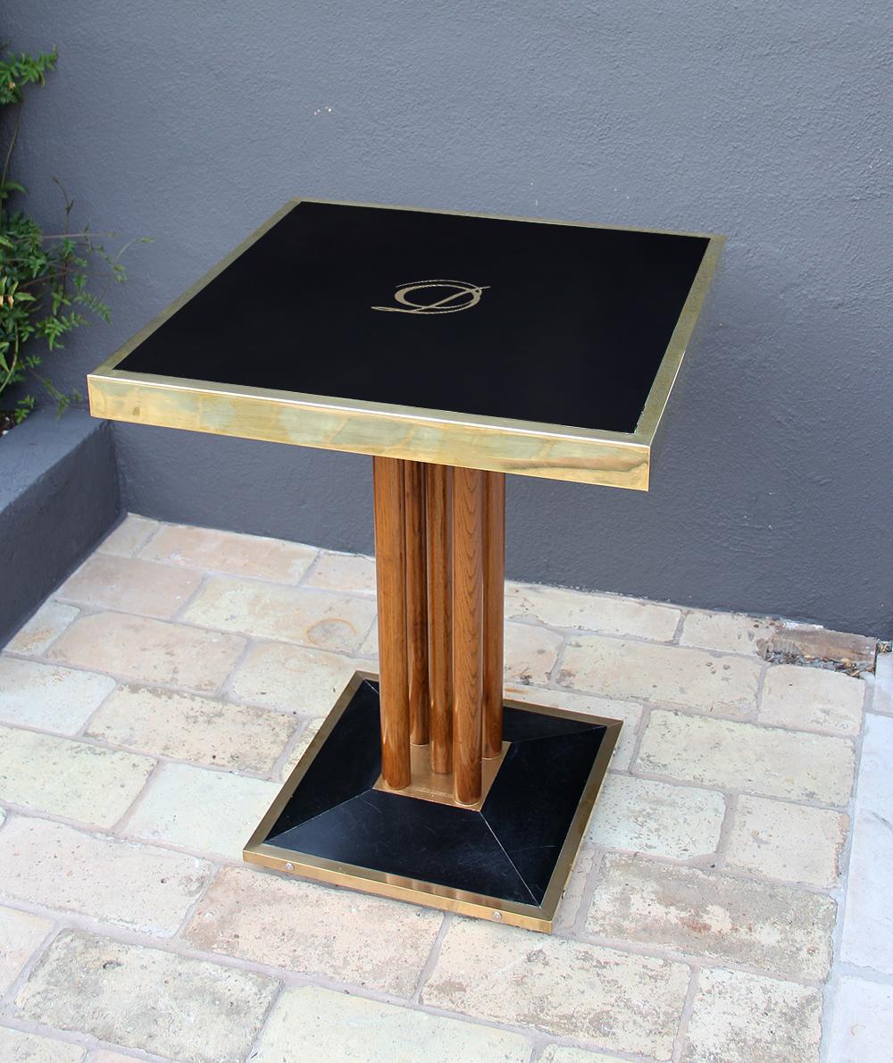 Very beautiful bistro (bistrot) table coming from the French restaurant, Drouant.
This square table is composed of a black glass framed in brass and mounted on a black base, which is also framed in brass.
The glass features a gilt logo.
The top and