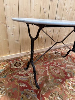 Bistro table with oval marble top and cast iron base