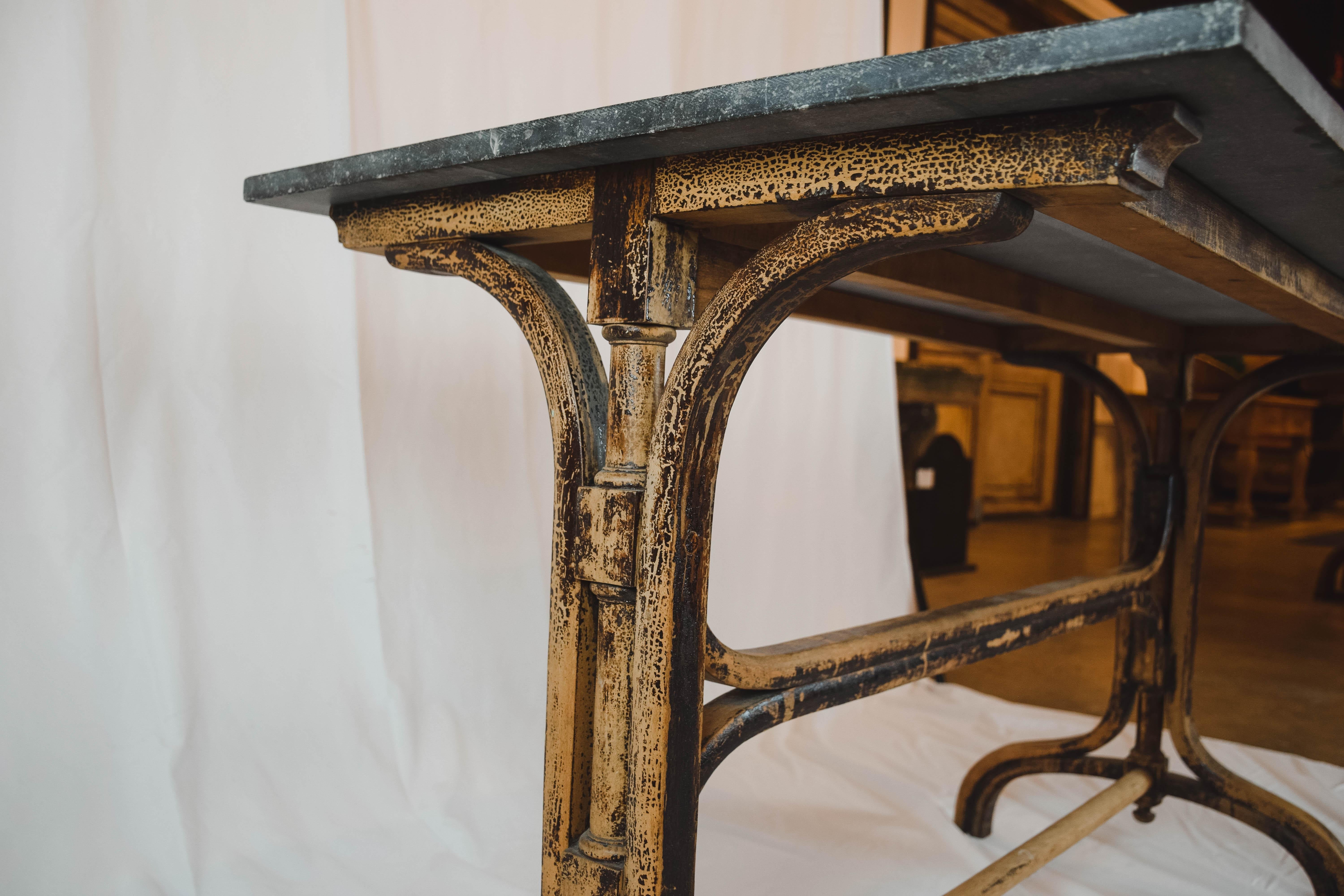 This graceful bistro table features a dark gray stone top on a wooden base. It would be perfect in an entryway or used as a small console table.