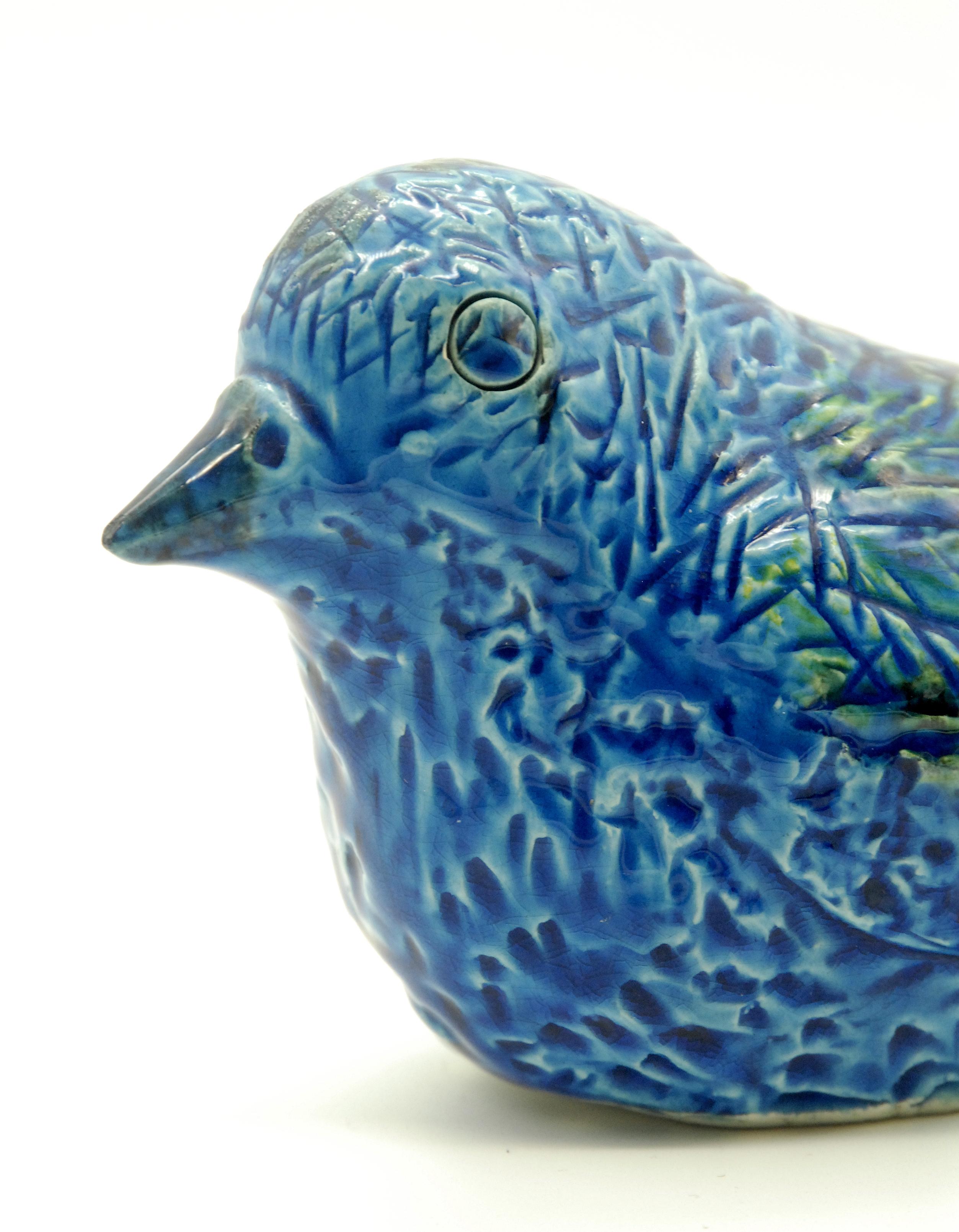 A late 1960s-1970s blue glazed bird, designed in 1963, with scraffito lines mimicking feathers under the glaze, with original paper label.