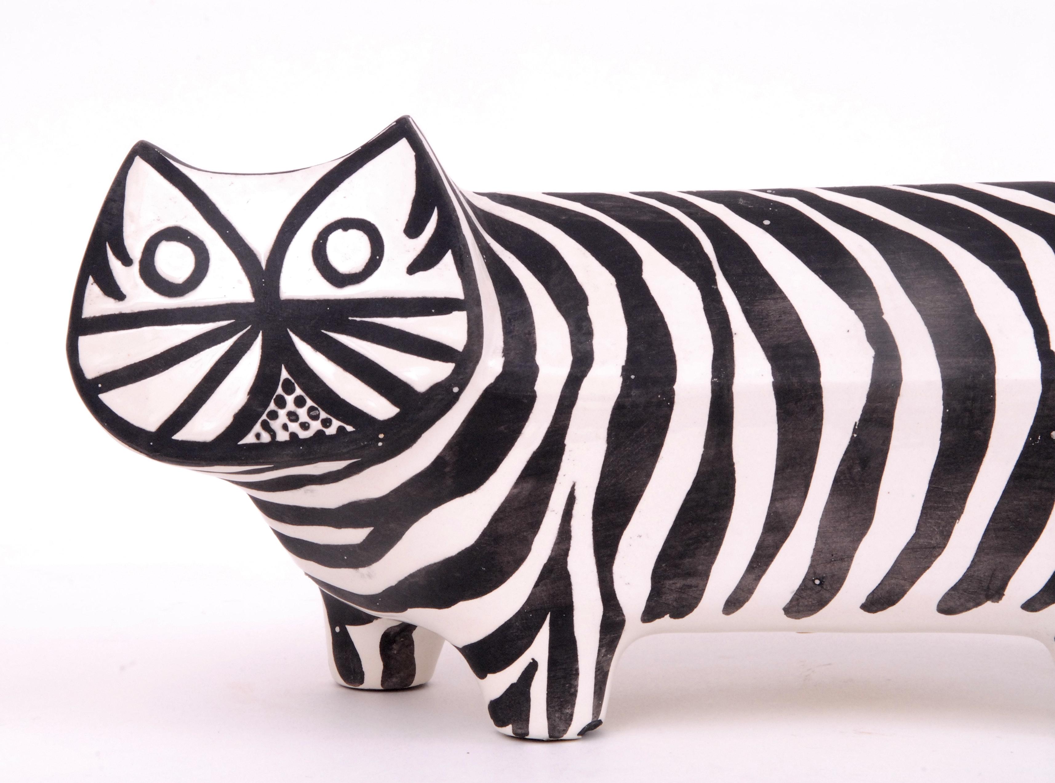 A lovely elongated walking cat in white with black stripes delineating its features. Signed in black underneath and with its original Raymor paper label.
One front foot has very minor damage to the inside section, not visible from the front.